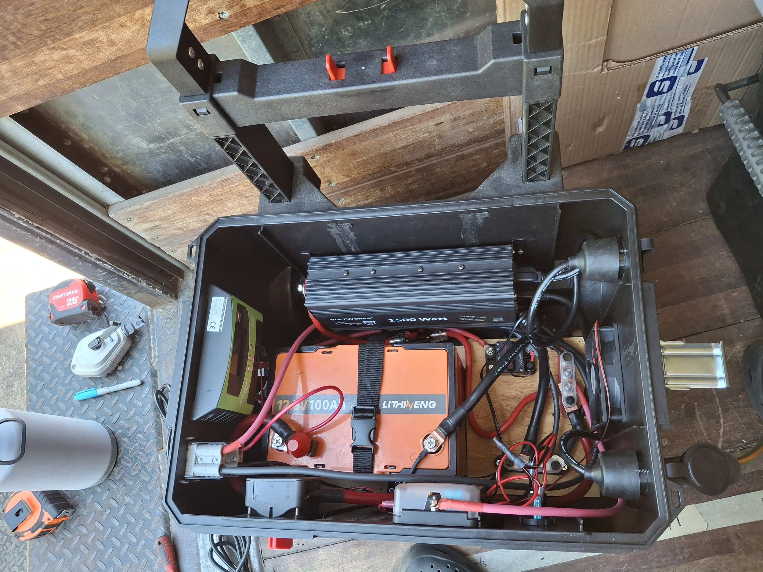 Early construction of the off-grid electrical system for Reidar Nettleship's 20-foot Isuzu NPR box truck conversion, featuring Victron Energy components, batteries, inverter, and wiring for a mobile storytelling studio and DIY off-grid RV.