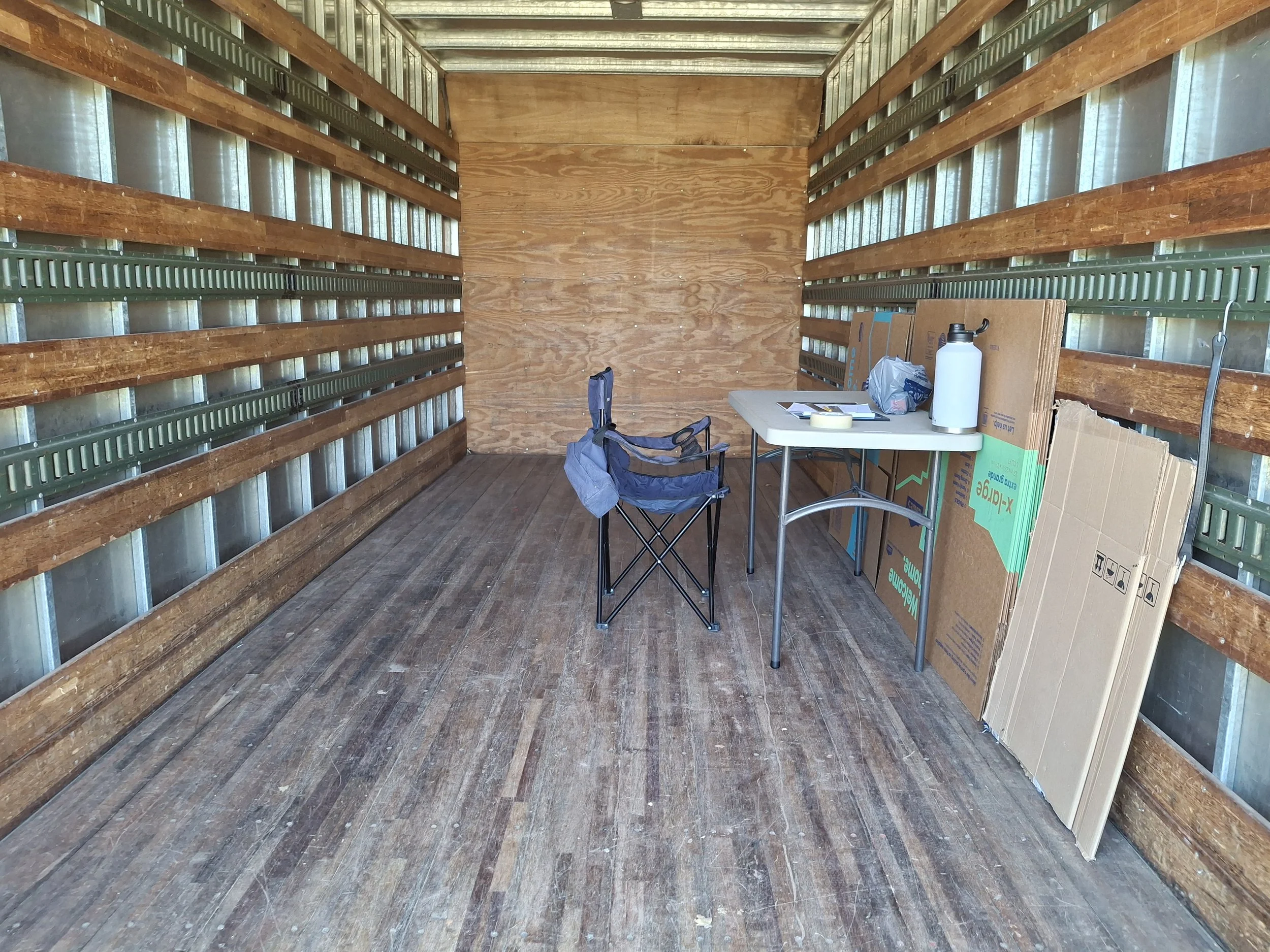 Interior of a 20-foot Isuzu NPR commercial box truck before conversion into an off-grid RV and mobile storytelling studio, showing the empty cargo area at the beginning of the DIY stealth RV build.