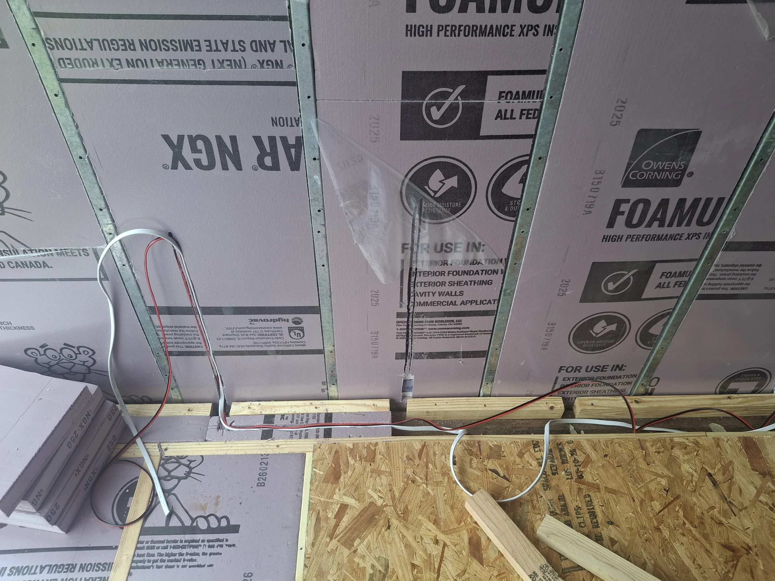 Ceiling insulation and electrical wiring installed inside an Isuzu NPR truck conversion using rigid foam insulation as part of a custom four-season off-grid stealth RV build.