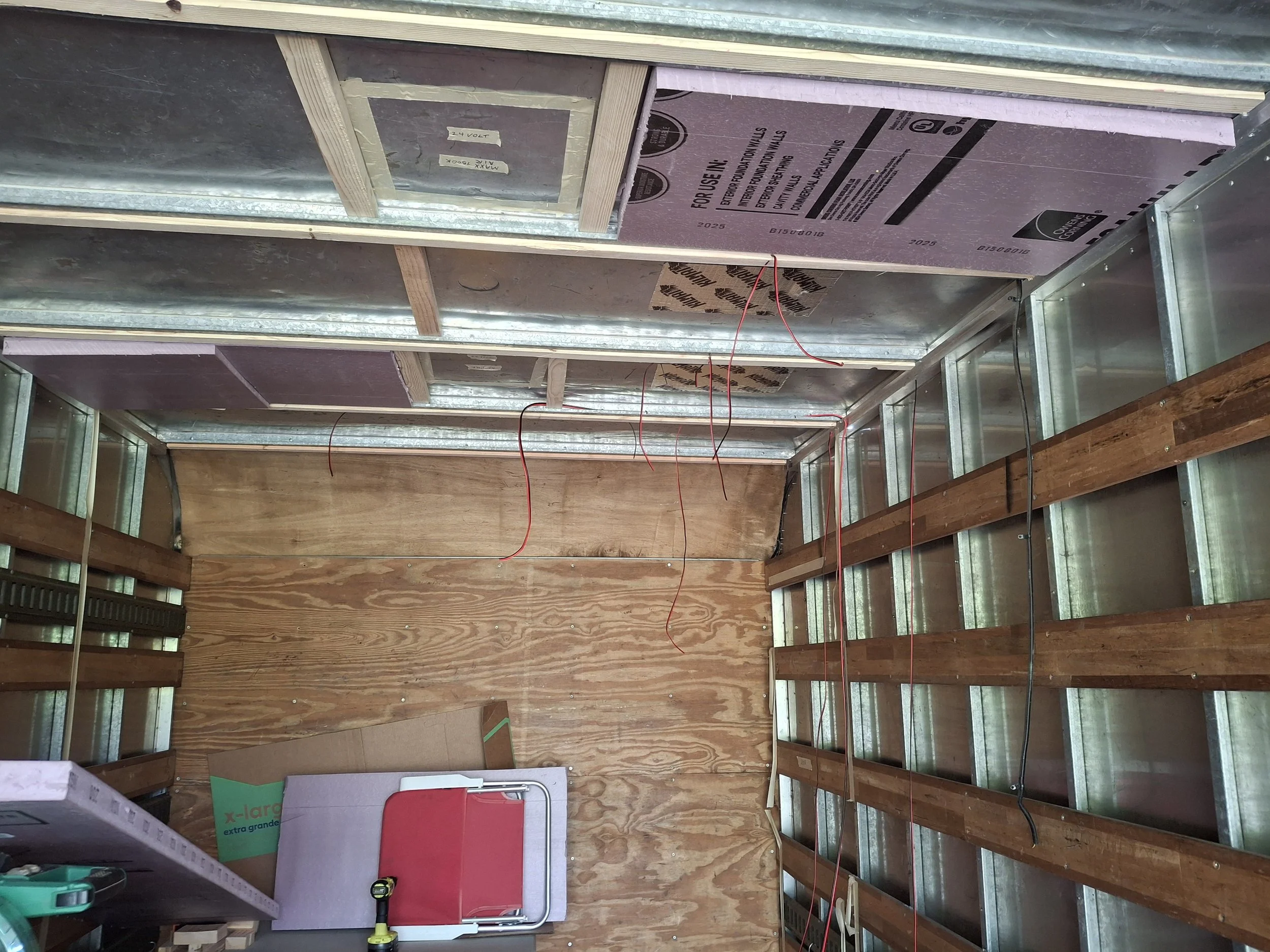 Interior framing and rough electrical wiring inside a 20-foot Isuzu NPR box truck during its transformation into a custom stealth off-grid RV, mobile storytelling studio, and DIY truck camper.