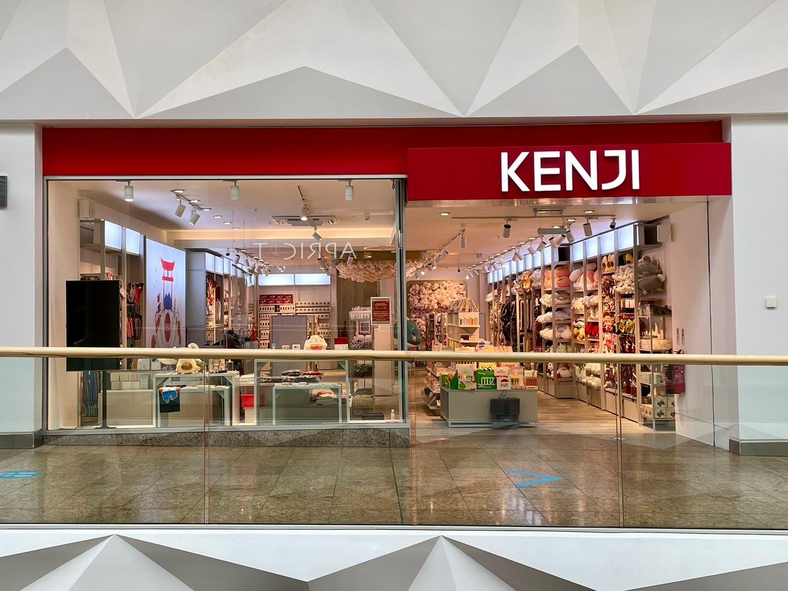 Storefront of Kenji store in a mall, featuring plush toys, home decor, and anime merchandise visible through glass windows.
