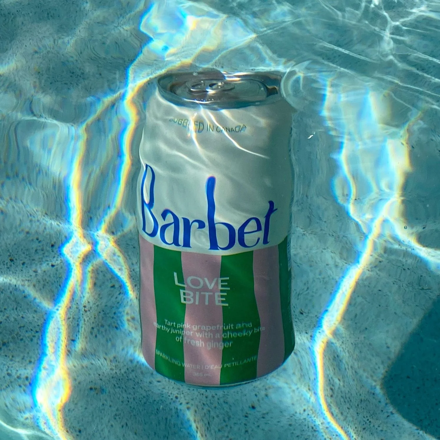 Barbet Love Bite sparkling water can submerged in a pool, pink grapefruit and ginger flavour, social content for a Toronto beverage brand