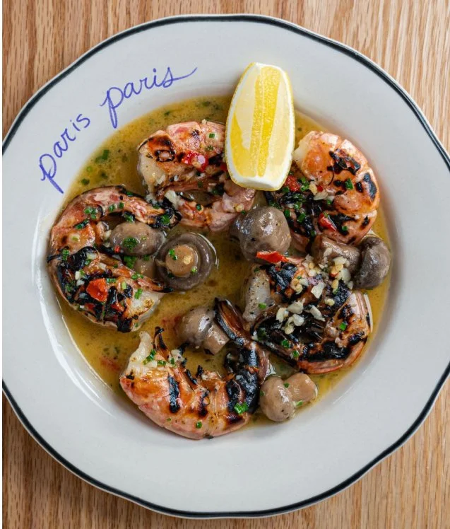 Grilled shrimp and mushrooms in garlic butter sauce on a Paris Paris branded plate, an example of social media content for hospitality businesses in Toronto