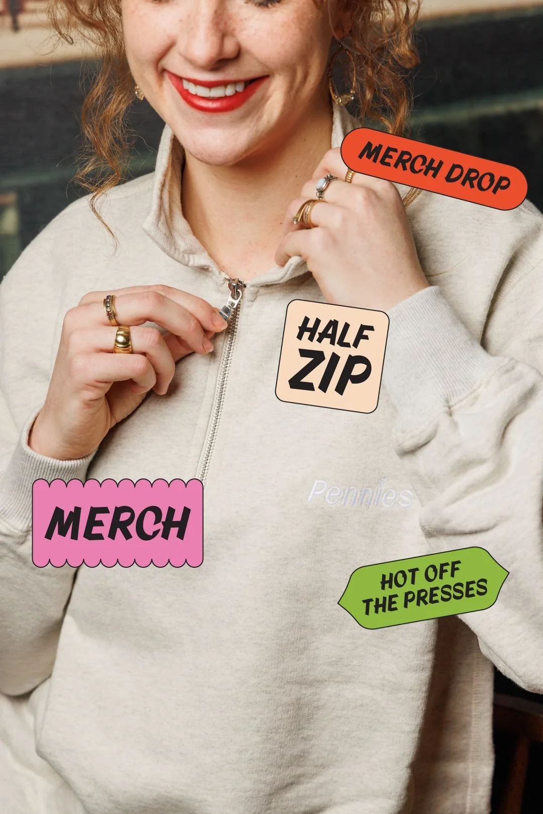 Woman zipping up a cream Pennies half-zip sweatshirt with Merch Drop and Hot Off the Presses graphic callouts, merch content for a Toronto hospitality brand