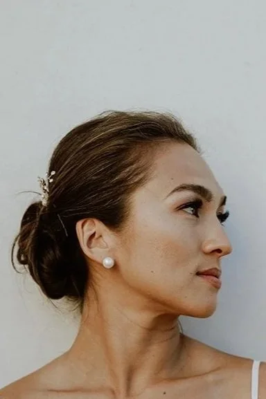 A profile view of Stephanie Weden, mother, teacher, and founder of WedenMG, with her hair pulled into a low bun and a slight smile.