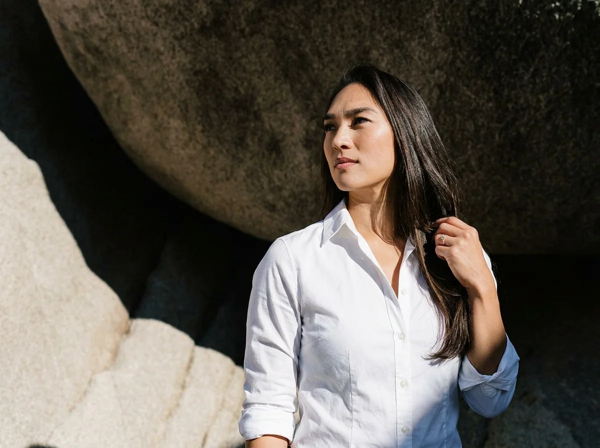 Stephanie Weden, mother, teacher, and founder of WedenMG,standing in front of a rock in a white button down shirt looking into the distance.
