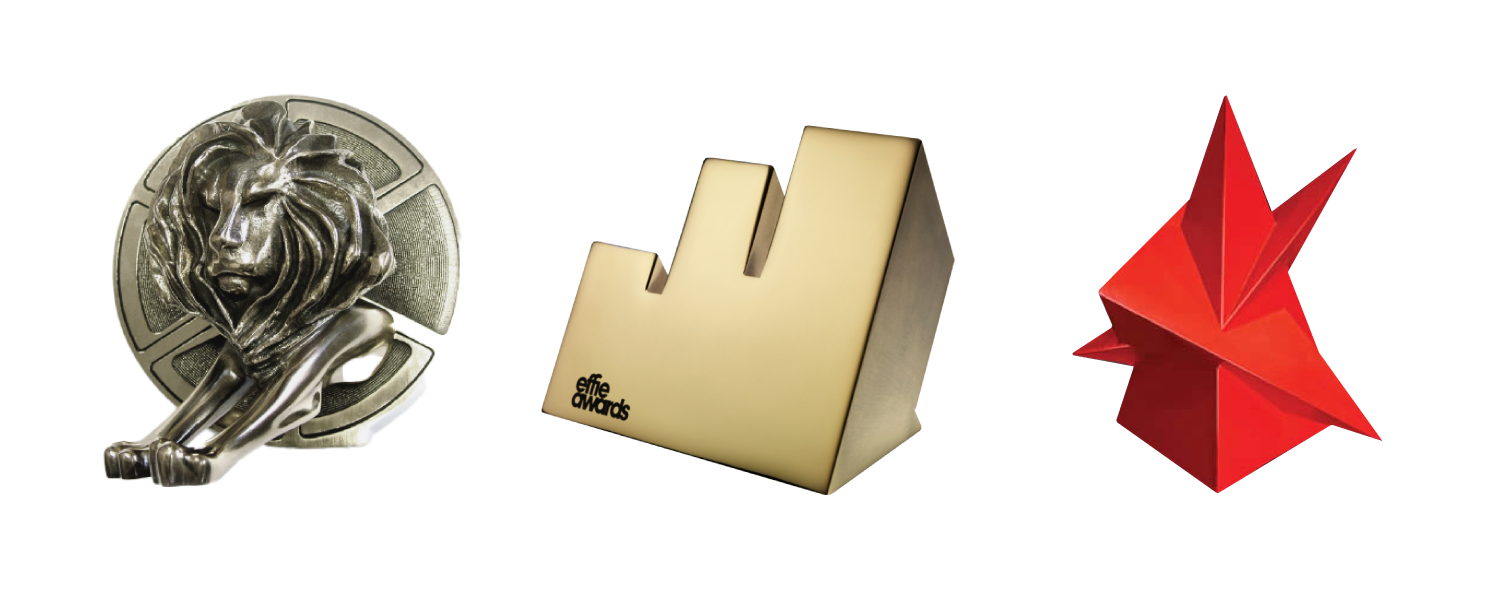 A lion sculpture, a gold award trophy, and a red origami-style star, Advertising awards.