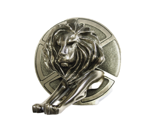 A metallic emblem featuring a lion's head with a flowing mane and a circular background with ventilation holes.