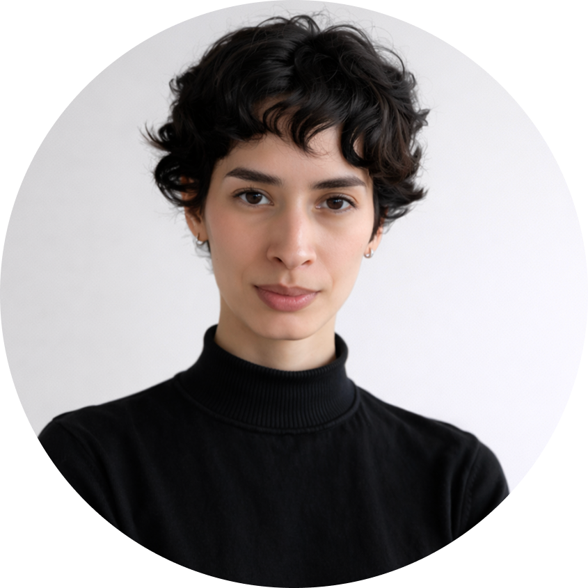 Young woman with short curly dark hair wearing a black turtleneck sweater against a light background.