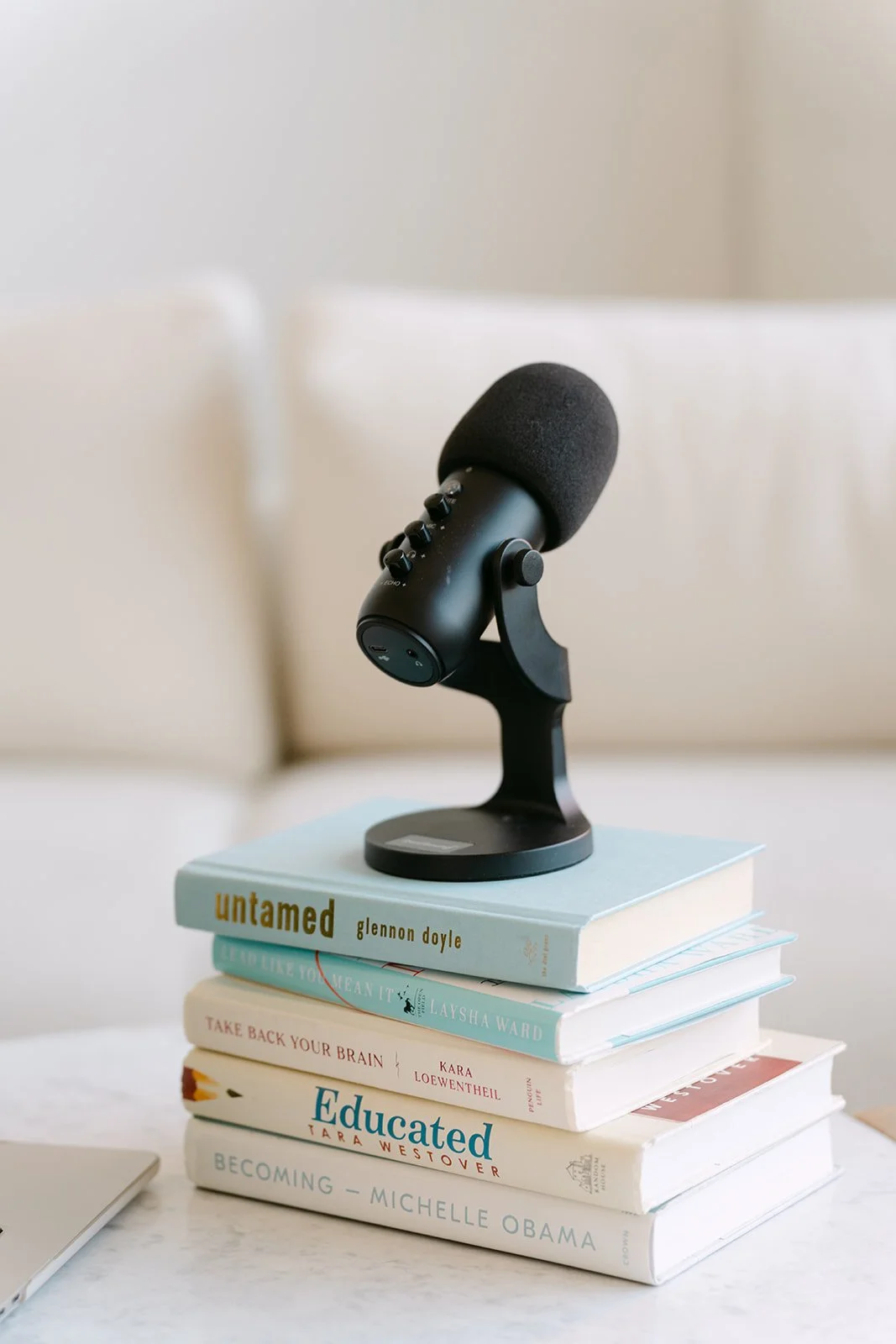 Microphone placed on top of a stack of books on a table.