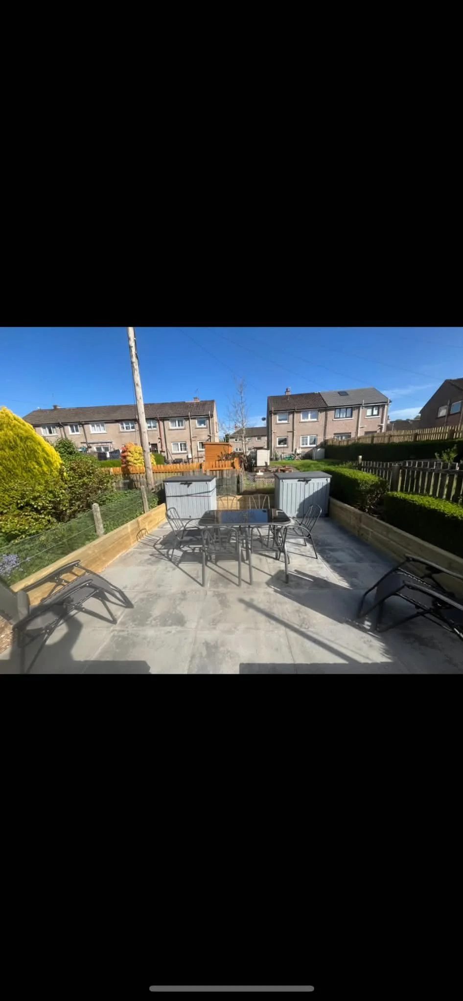 Slabbed patio. sleeper retaining wall