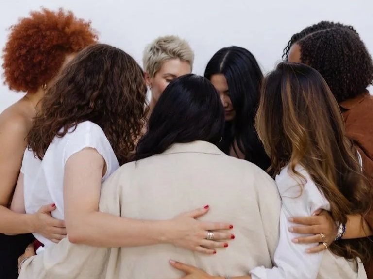 Group of women hugging and comforting each other in a close group