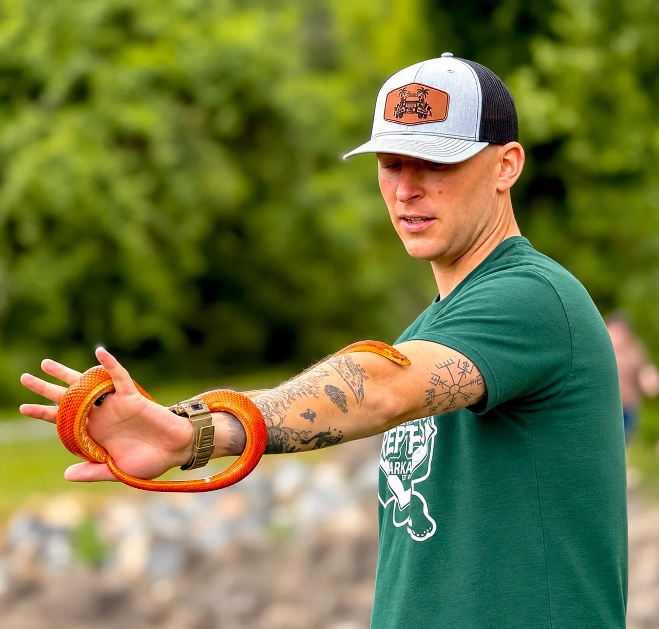 Zoo To You reptile educator holding a bright orange snake during an outdoor educational reptile program in Arkansas
