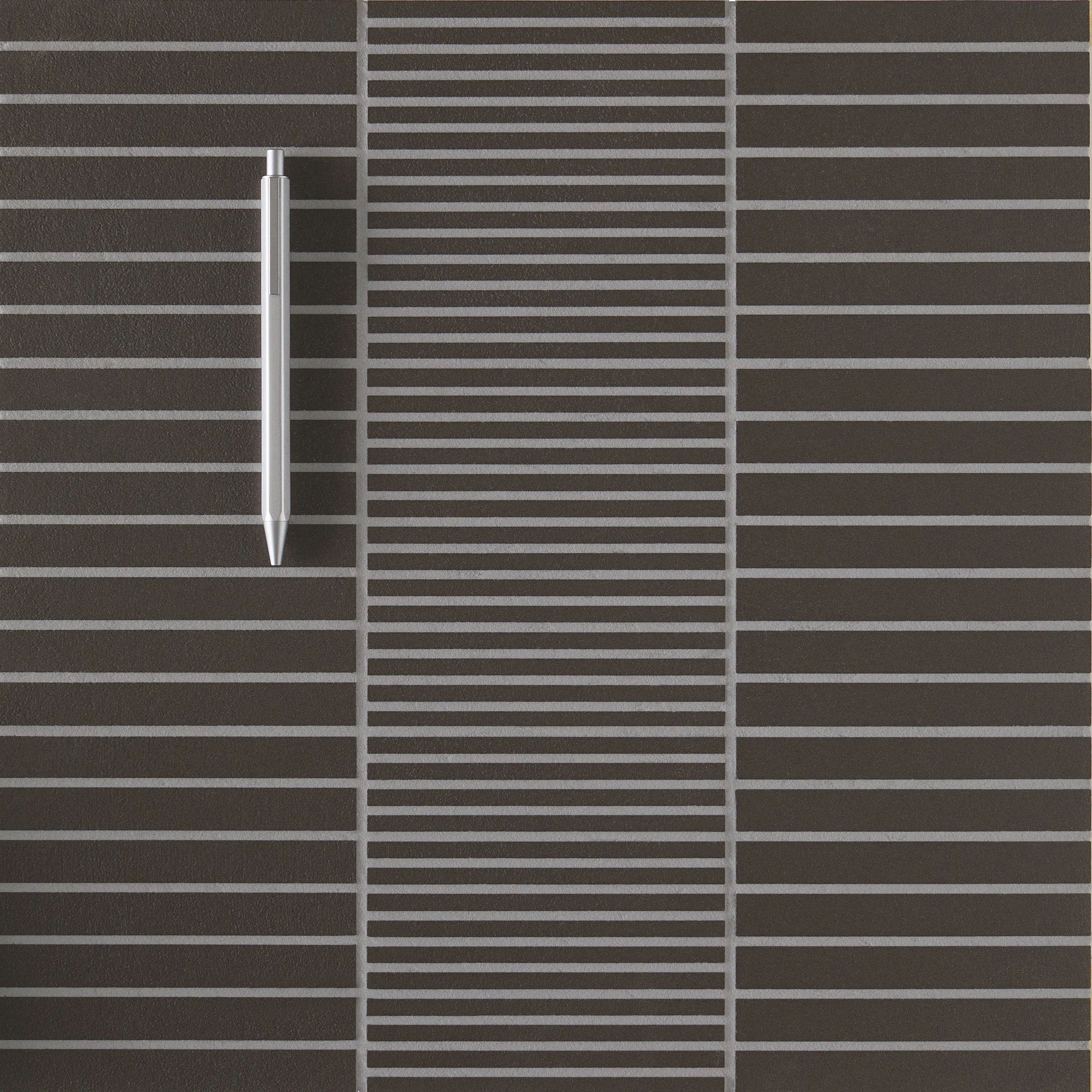 Pen arranged on a geometric tiled surface - Weather exhibition by Michael Anastassiades.