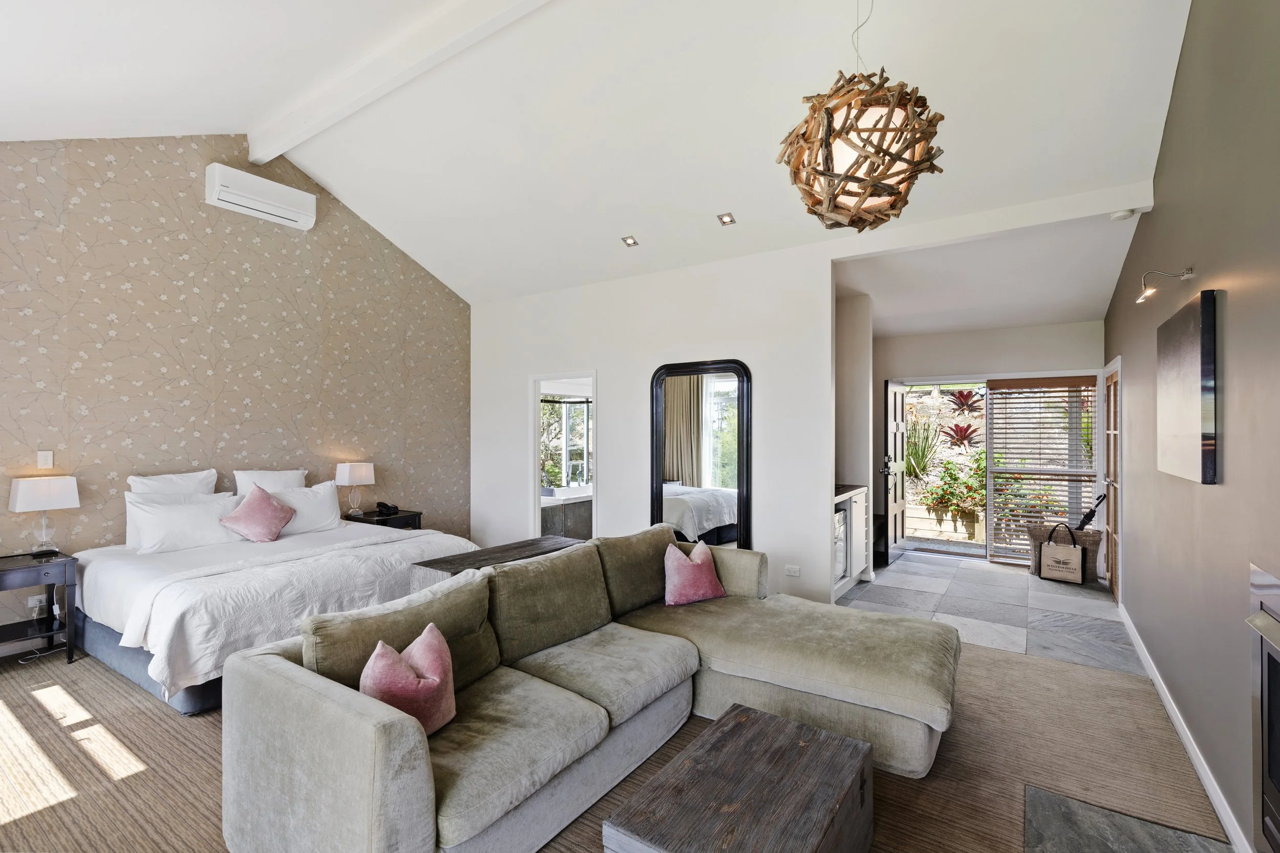 Spacious villa accommodation at Woodhouse Mountain Lodge in Matakana with king bed, lounge area and private outdoor courtyard.