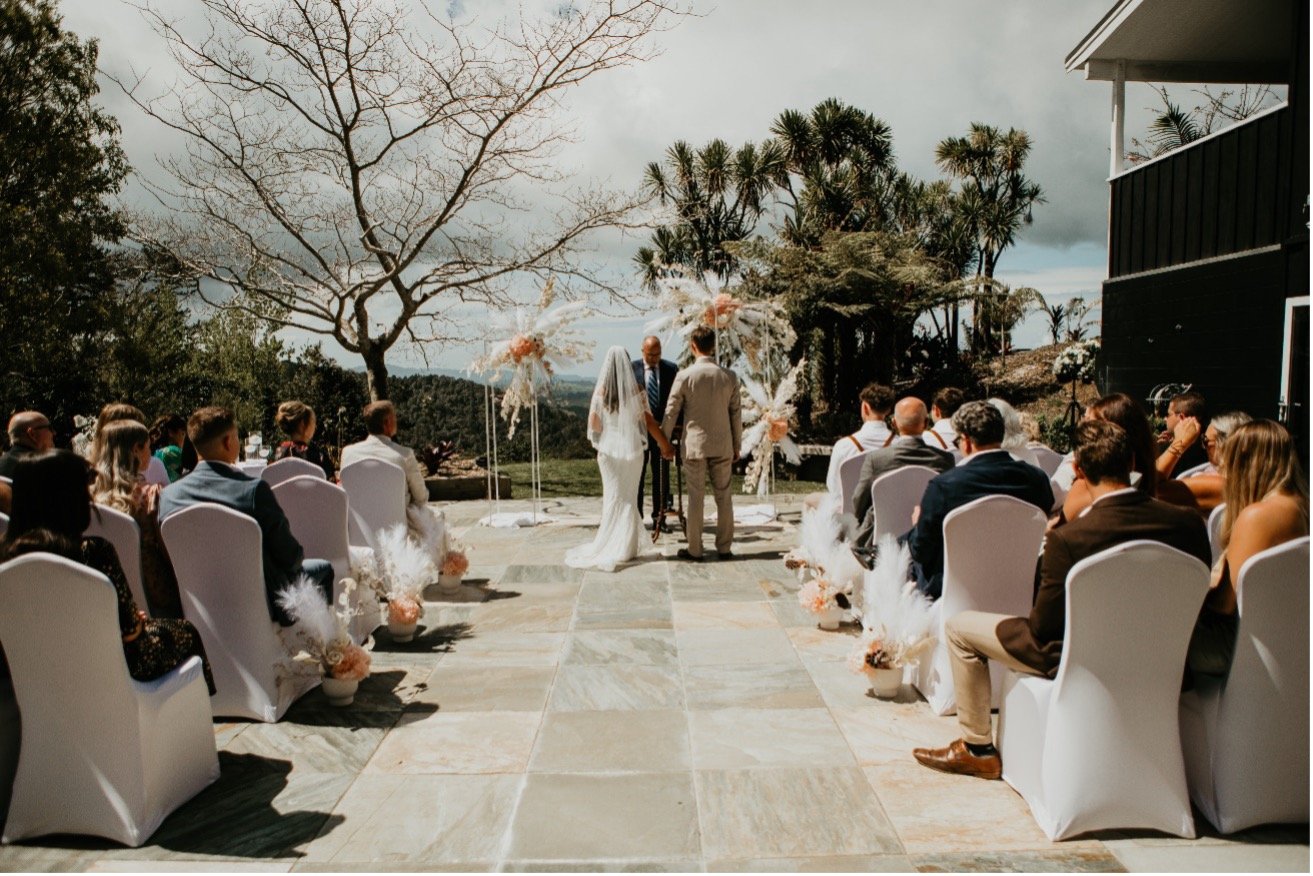 Outdoor wedding ceremony at a luxury lodge on the Matakana Coast near Warkworth, New Zealand.