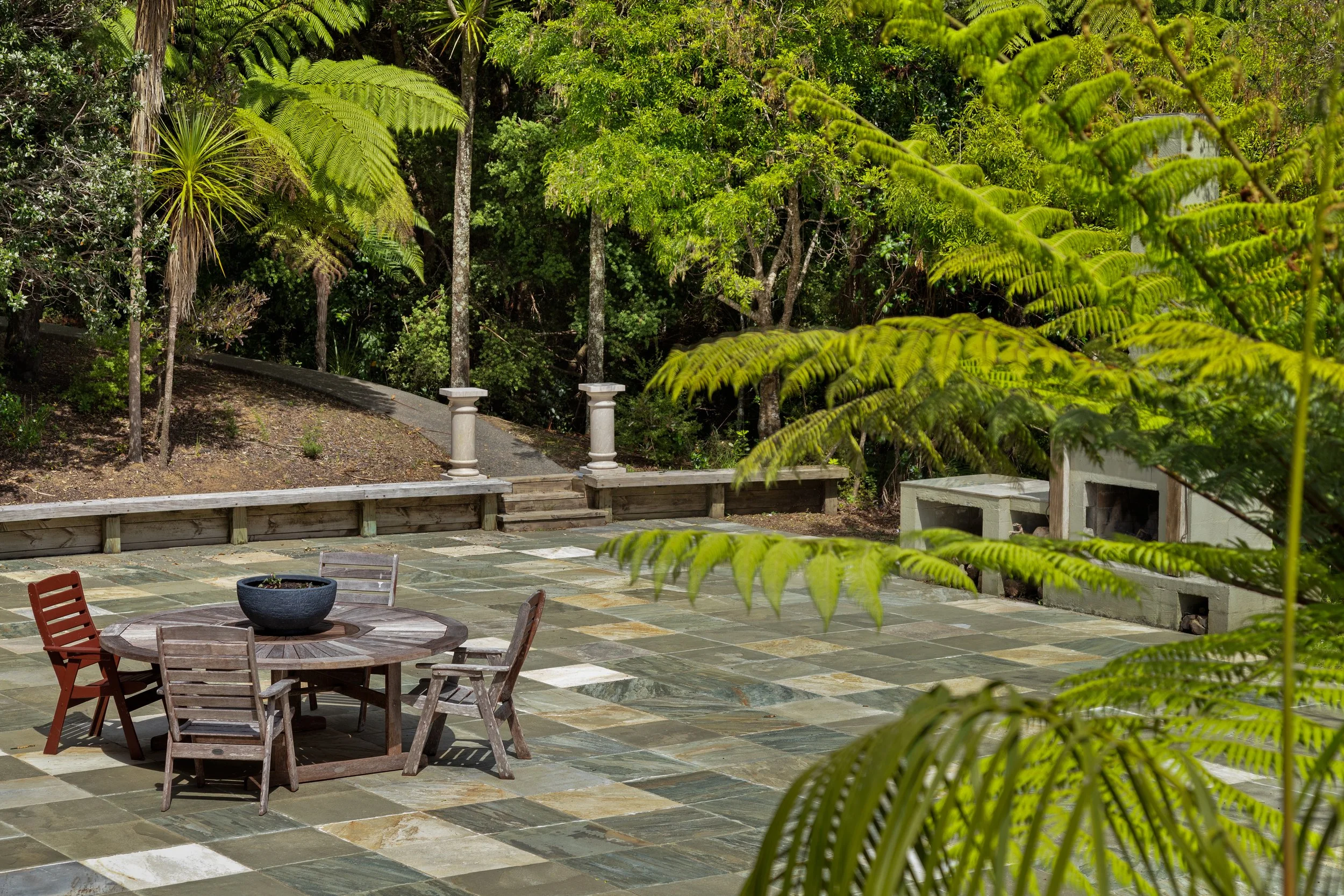 Private outdoor courtyard surrounded by native greenery at Woodhouse Mountain Lodge in Matakana.