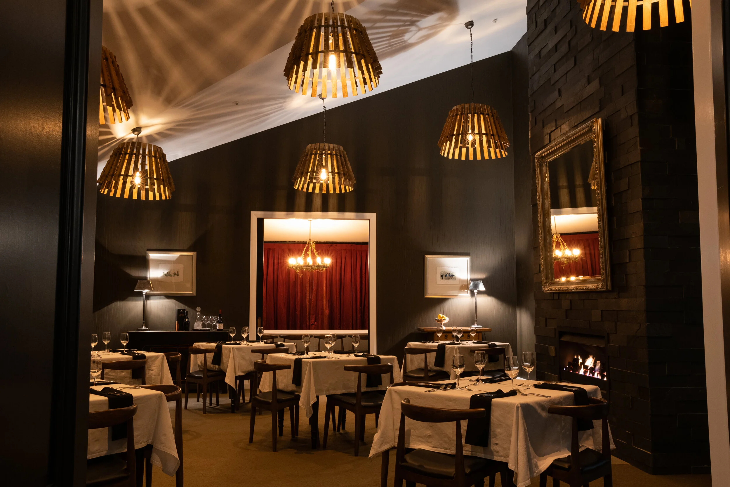 Restaurant dining room with fireplace at Woodhouse Mountain Lodge in Matakana