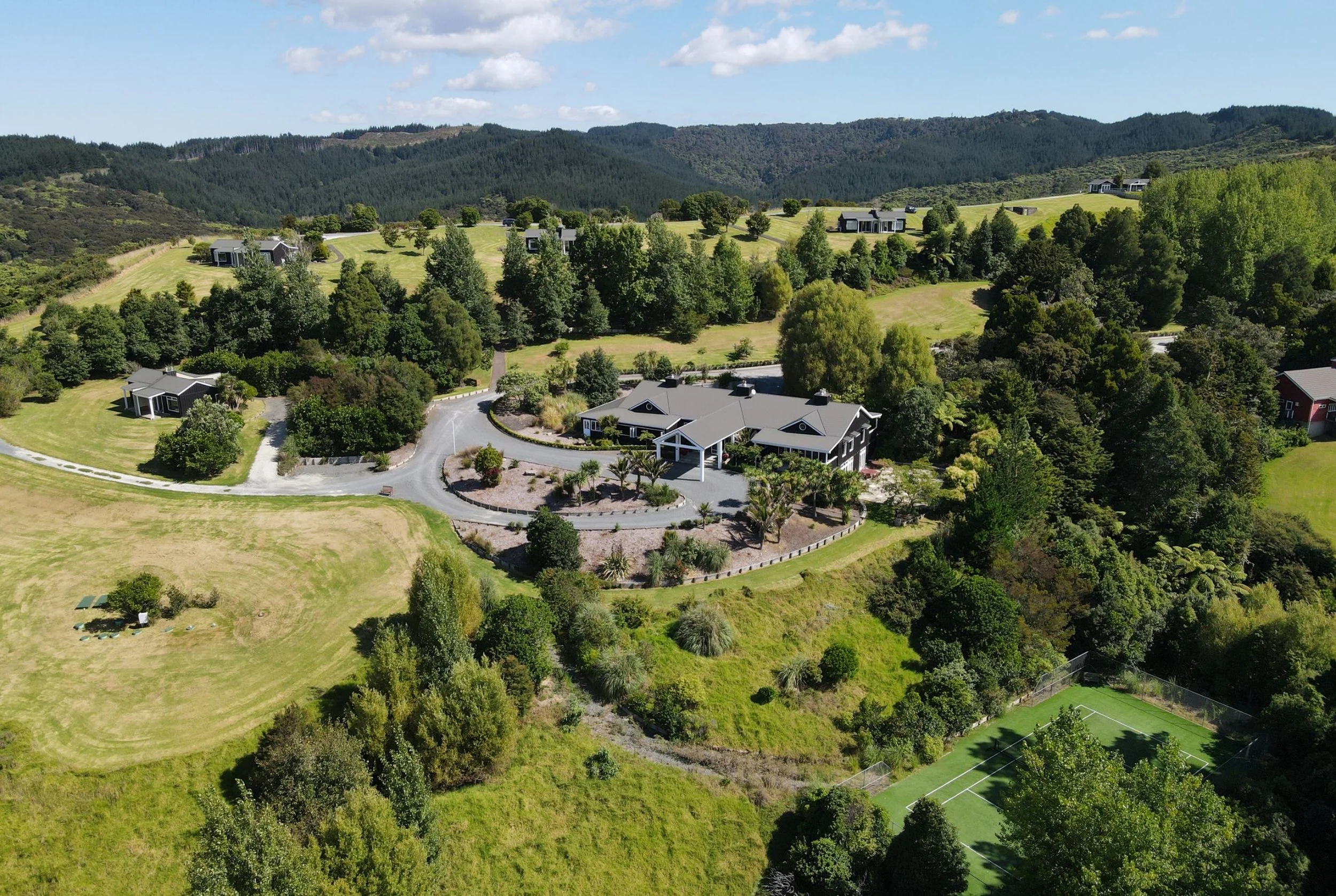 Aerial view of Woodhouse Mountain Lodge in the Matakana hinterland surrounded by expansive countryside and native bush.