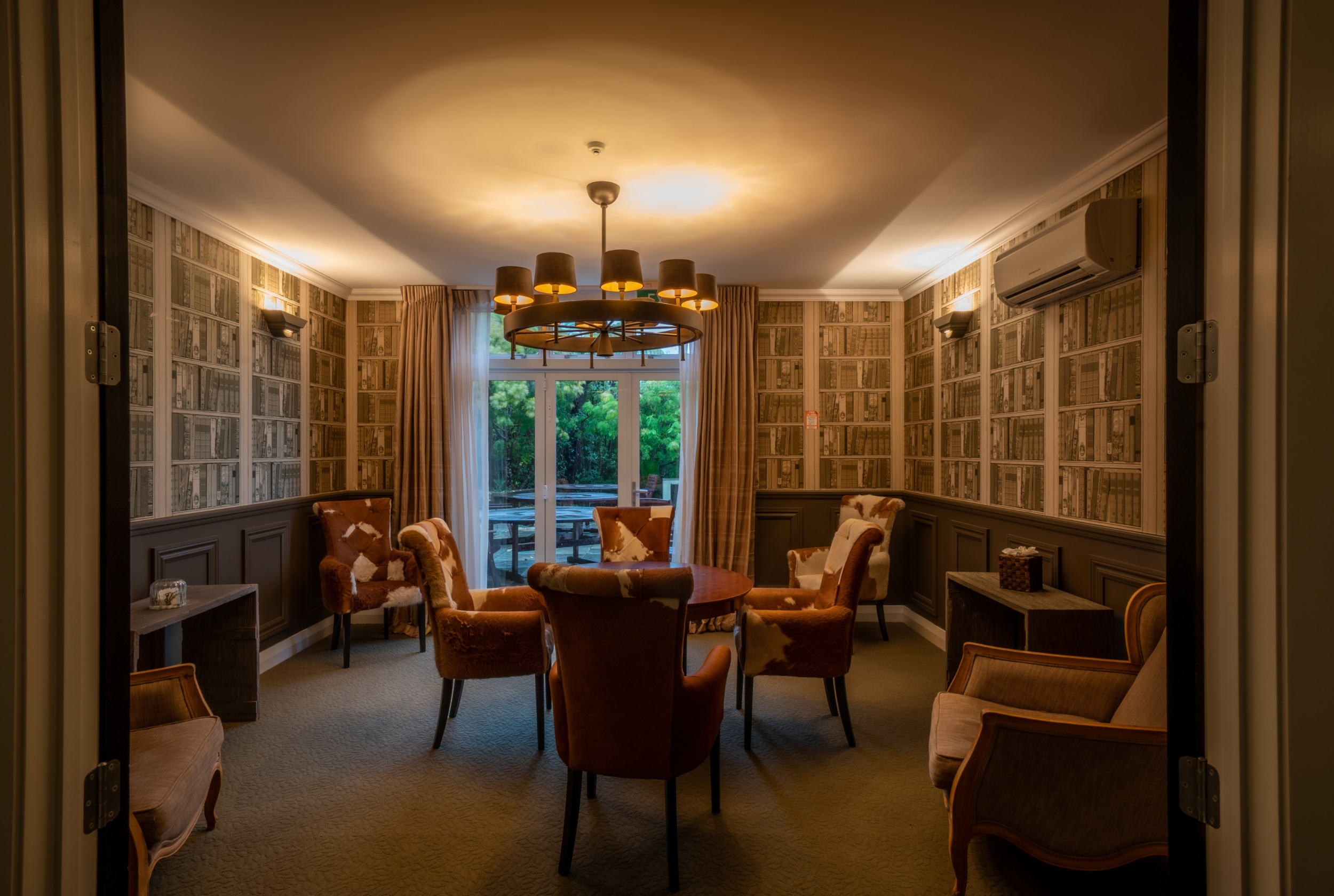 Intimate meeting room at Woodhouse Mountain Lodge in Matakana with comfortable seating and courtyard access.