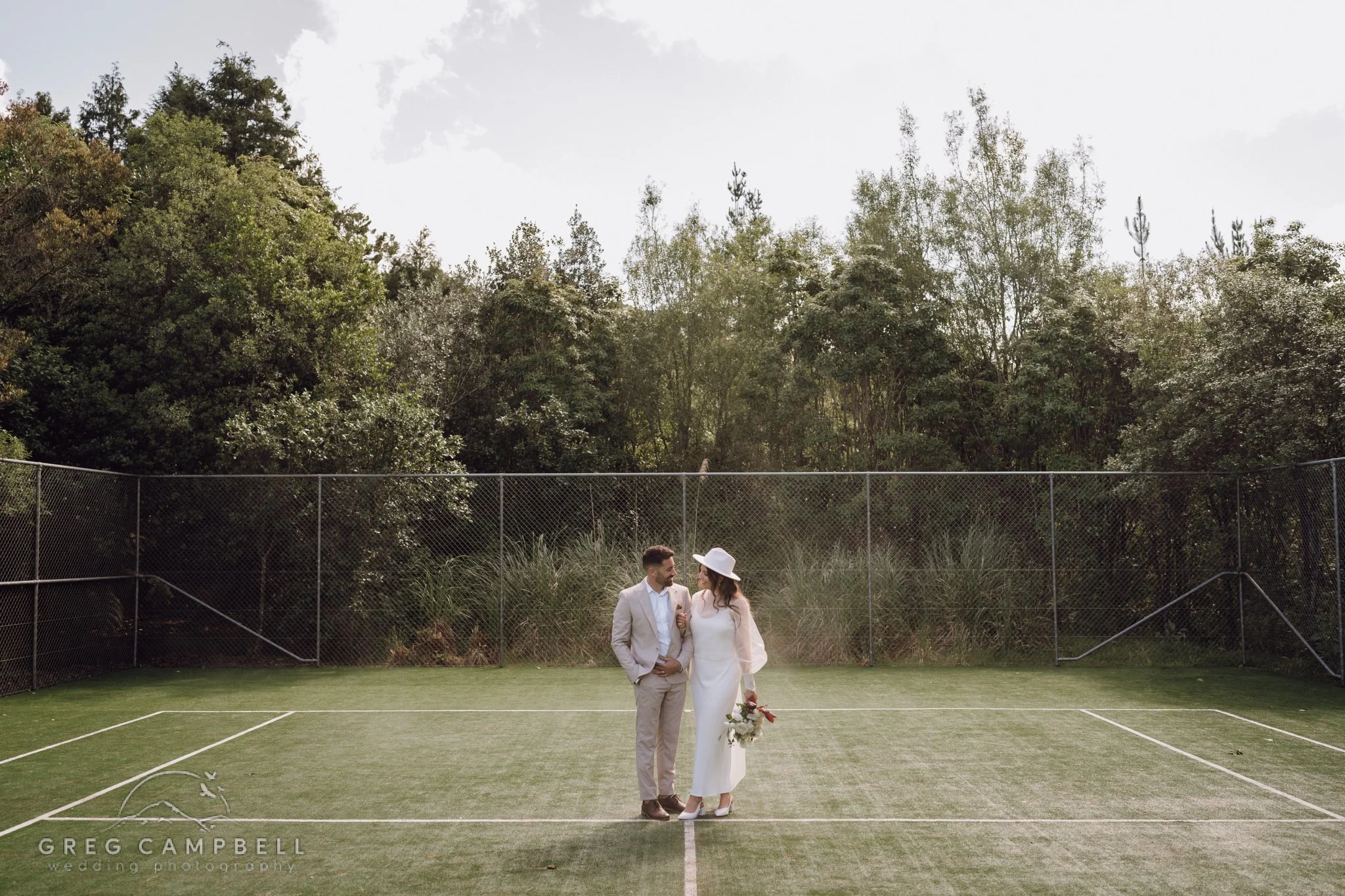 Romantic outdoor ceremony in the rain with umbrellas and joyful laughter captured in candid moments.