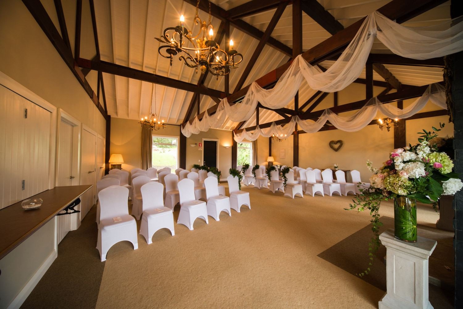 Indoor wedding ceremony venue at Woodhouse Mountain Lodge in Matakana with high ceilings and elegant décor.