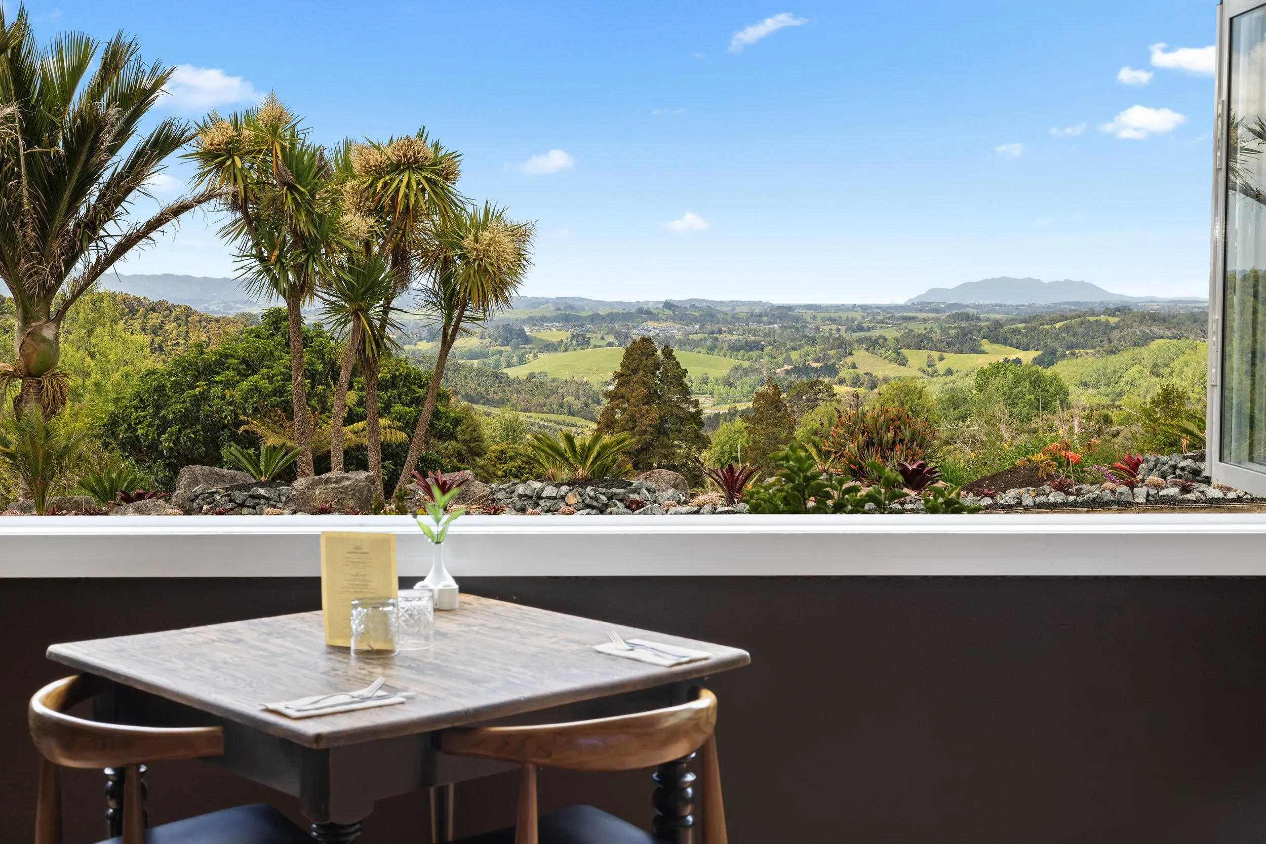 Restaurant table overlooking the Matakana countryside at Woodhouse Mountain Lodge