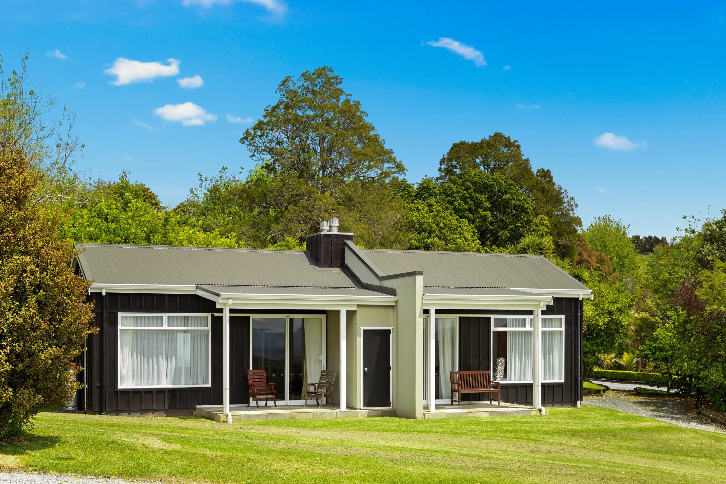 Woodhouse Mountain Lodge in the Matakana hinterland surrounded by lawns and native greenery.