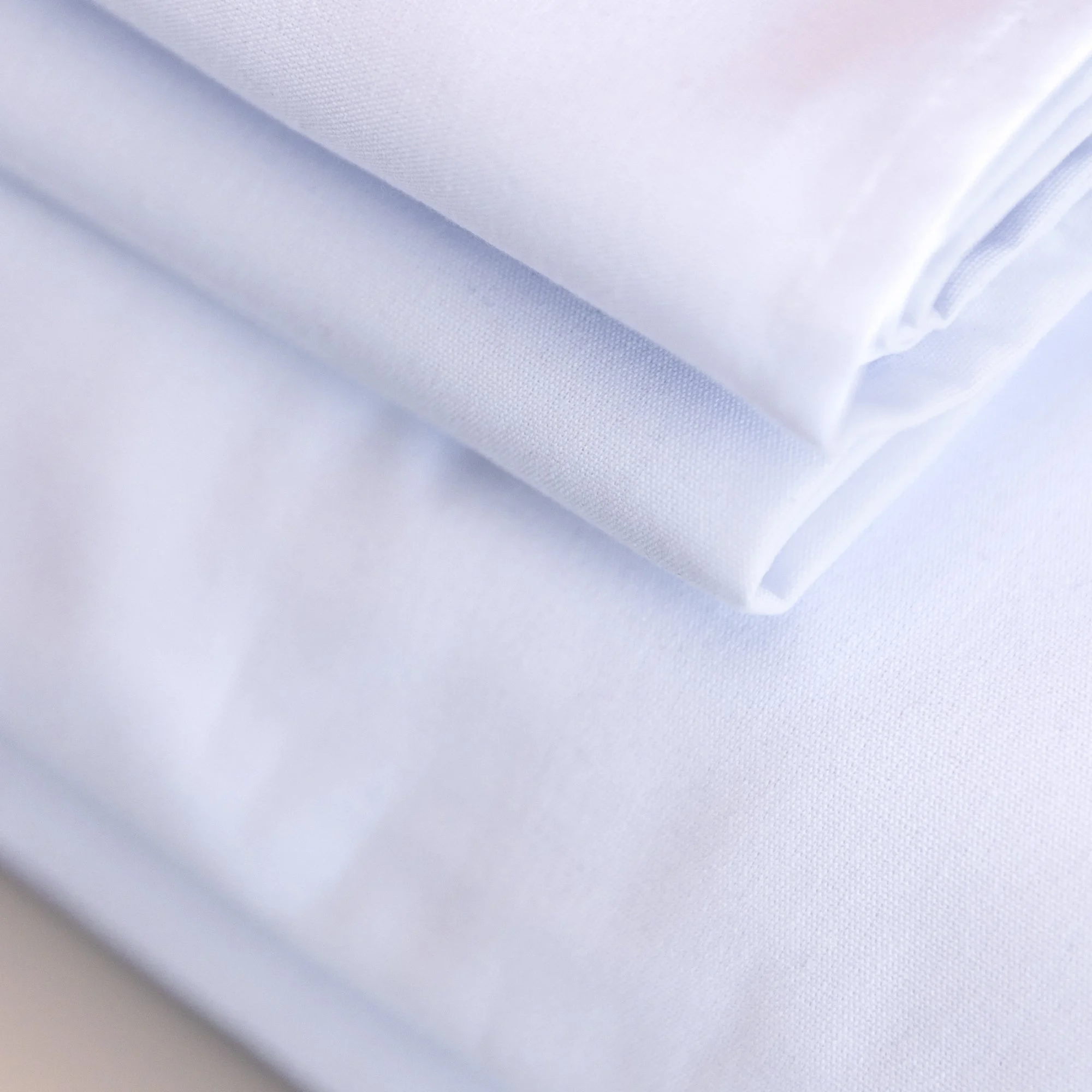 Close-up of white ring spun polyester tablecloth drape — stain resistant event linen NZ
