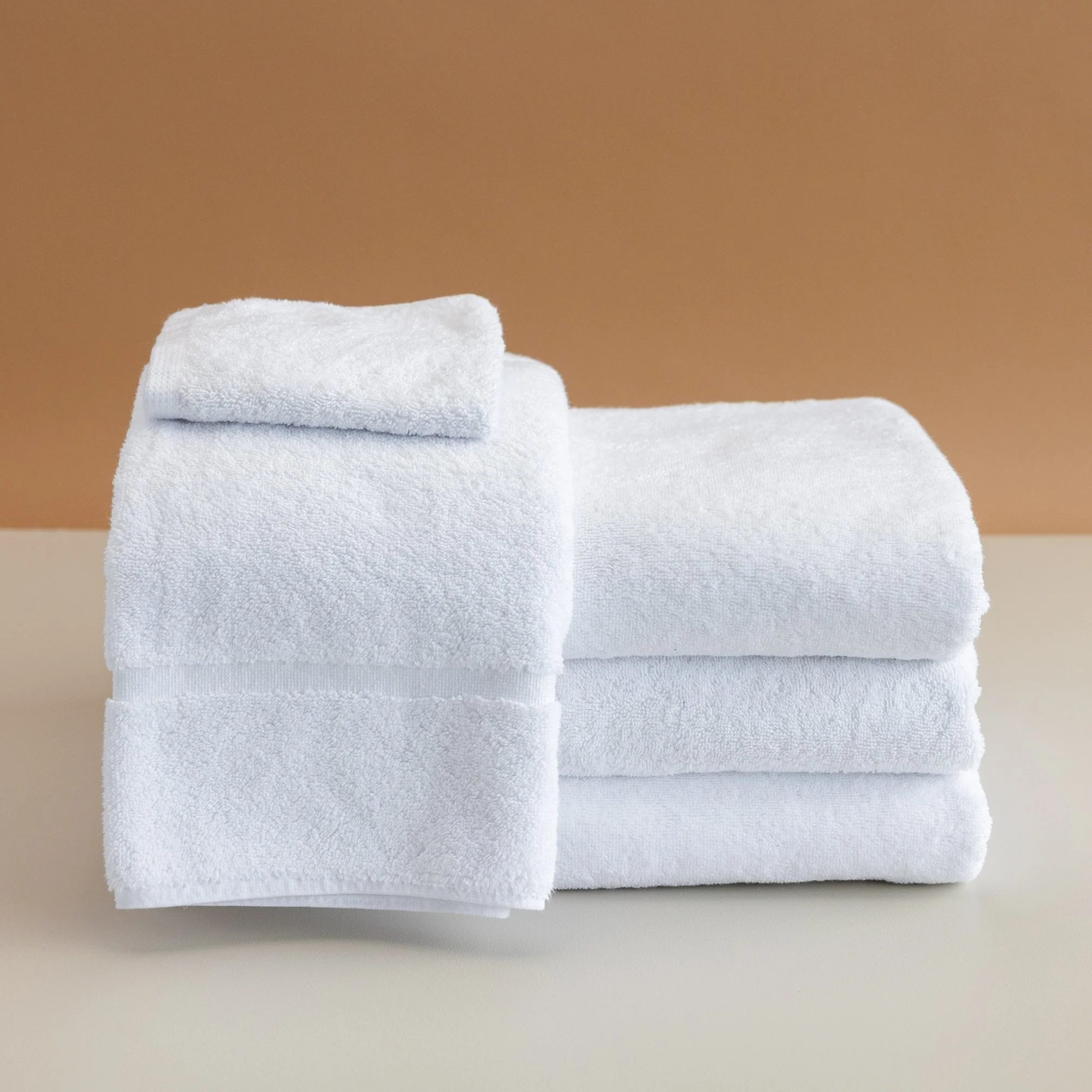 Tasman white towels on a beige background.