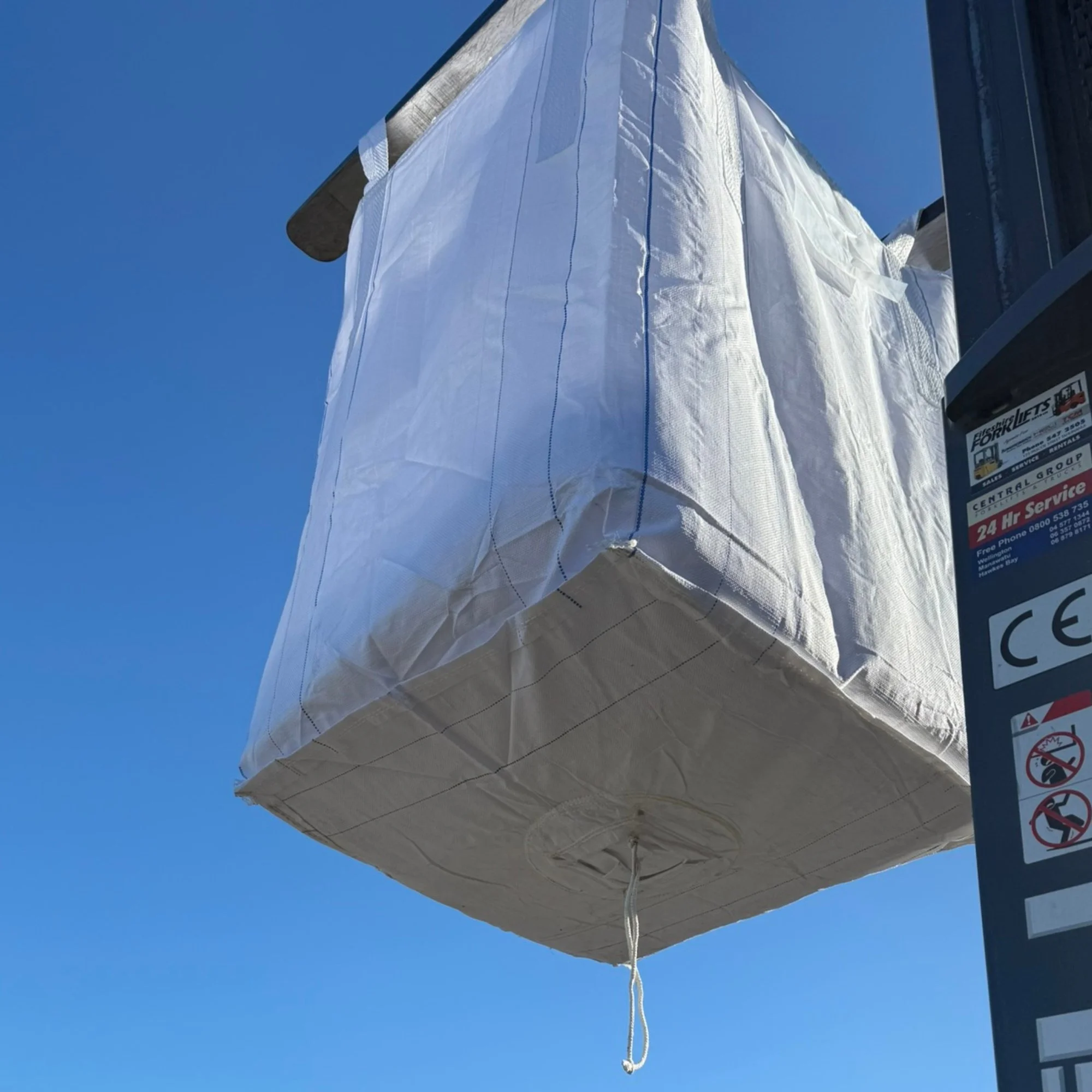 FIBC bag lifted onto forklift, with discharge spout and petal closure