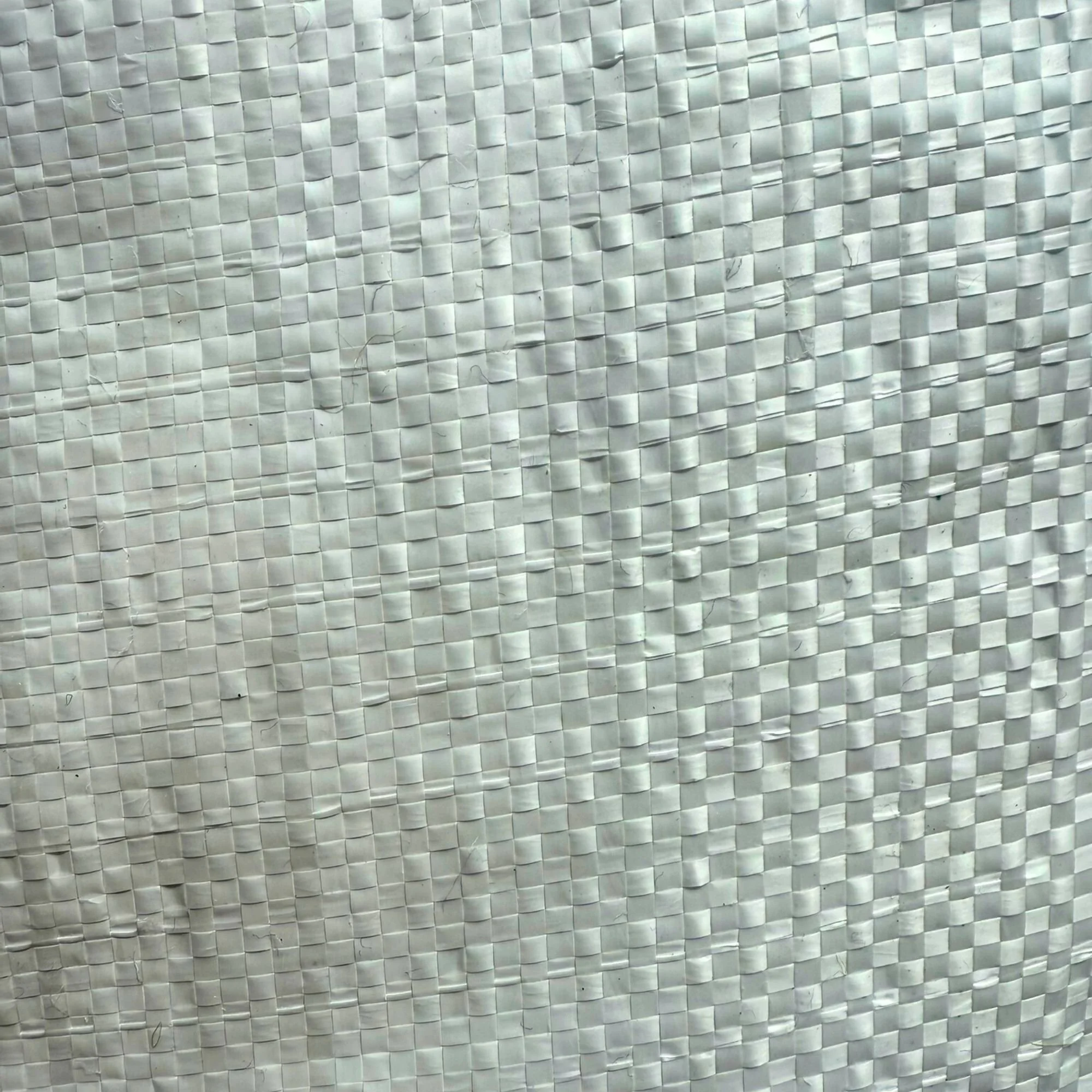 Close-up view of a textured white woven polypropylene bag