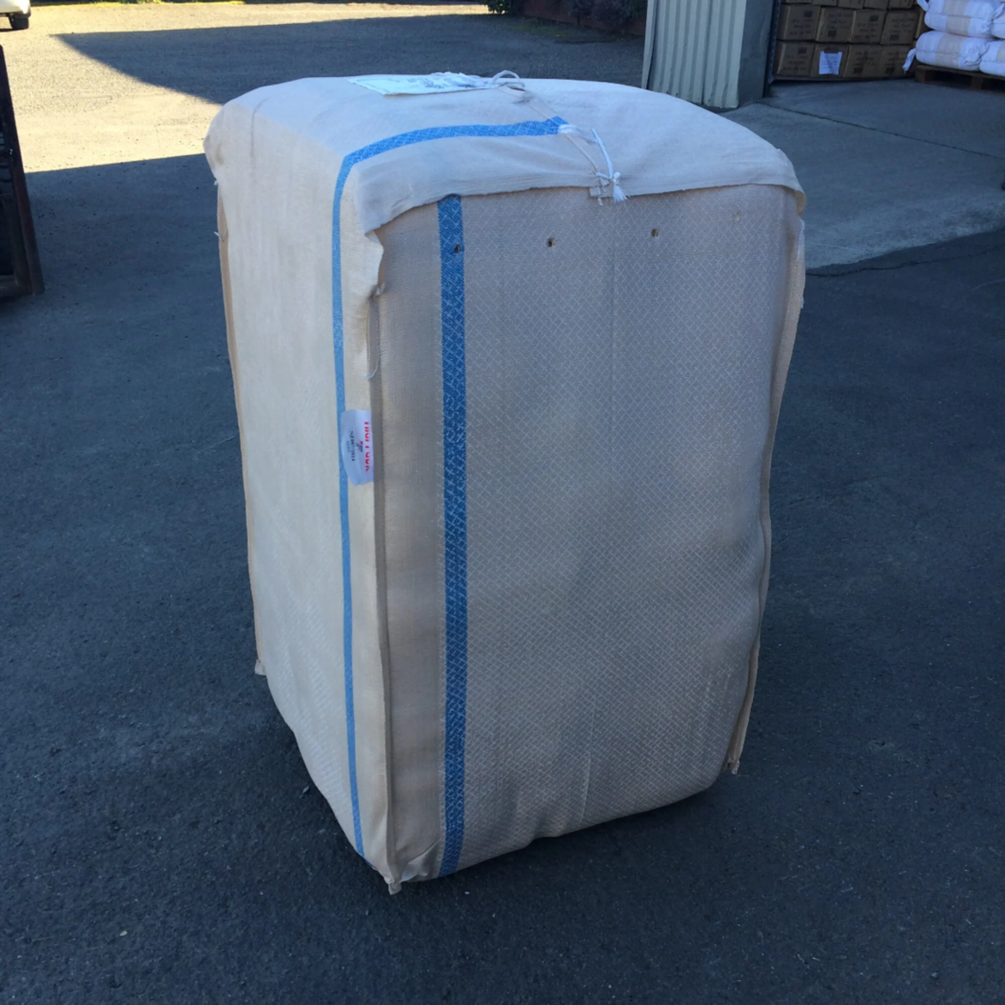HDPE Wool Pack placed outdoors on pavement near a warehouse or industrial area.
