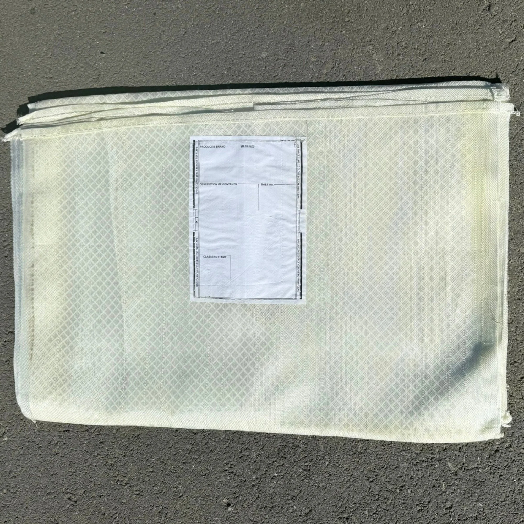 A White Nylon Woolpack, lying on a paved surface.