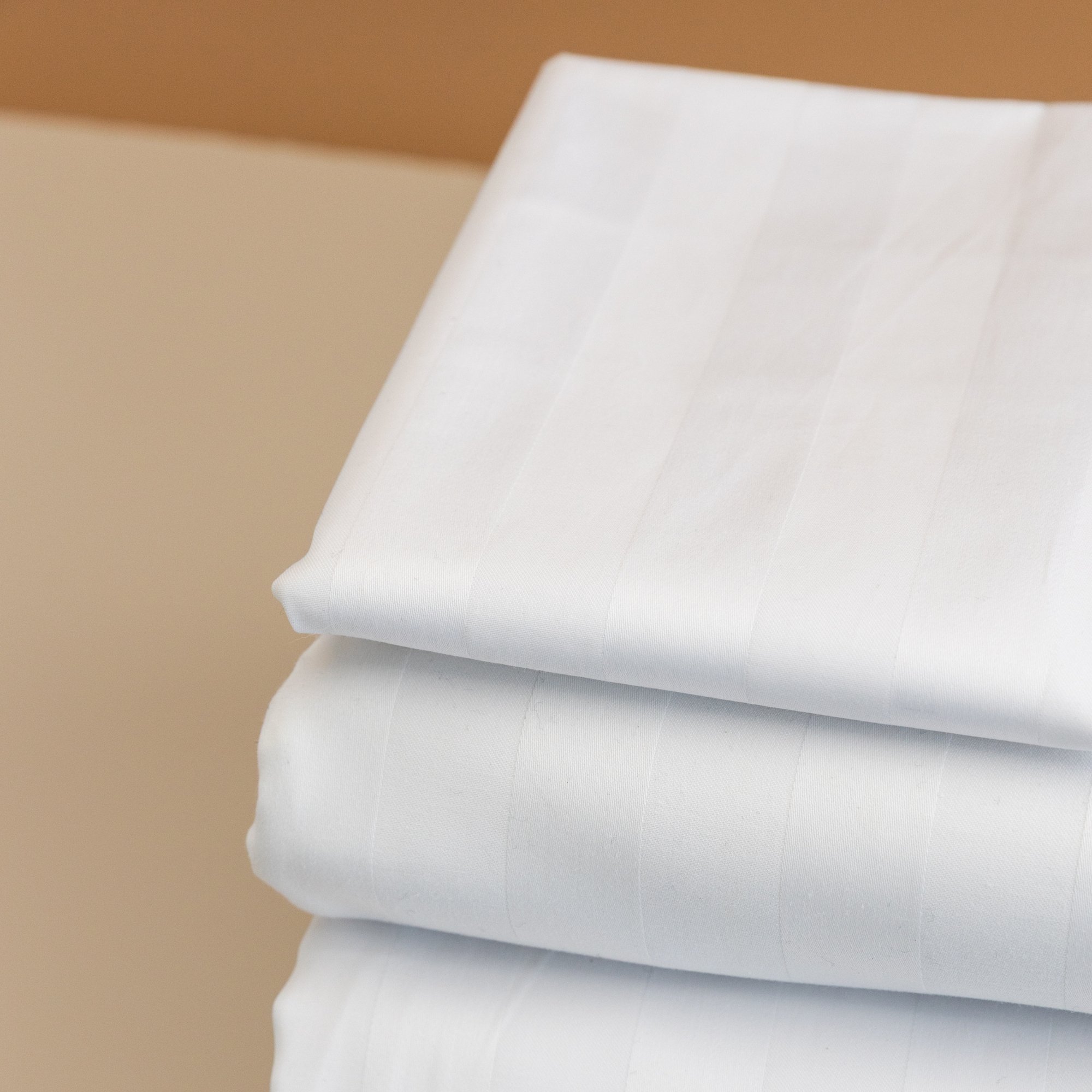 Stacked white folded Rutherford 25mm Striped Sheet Set.