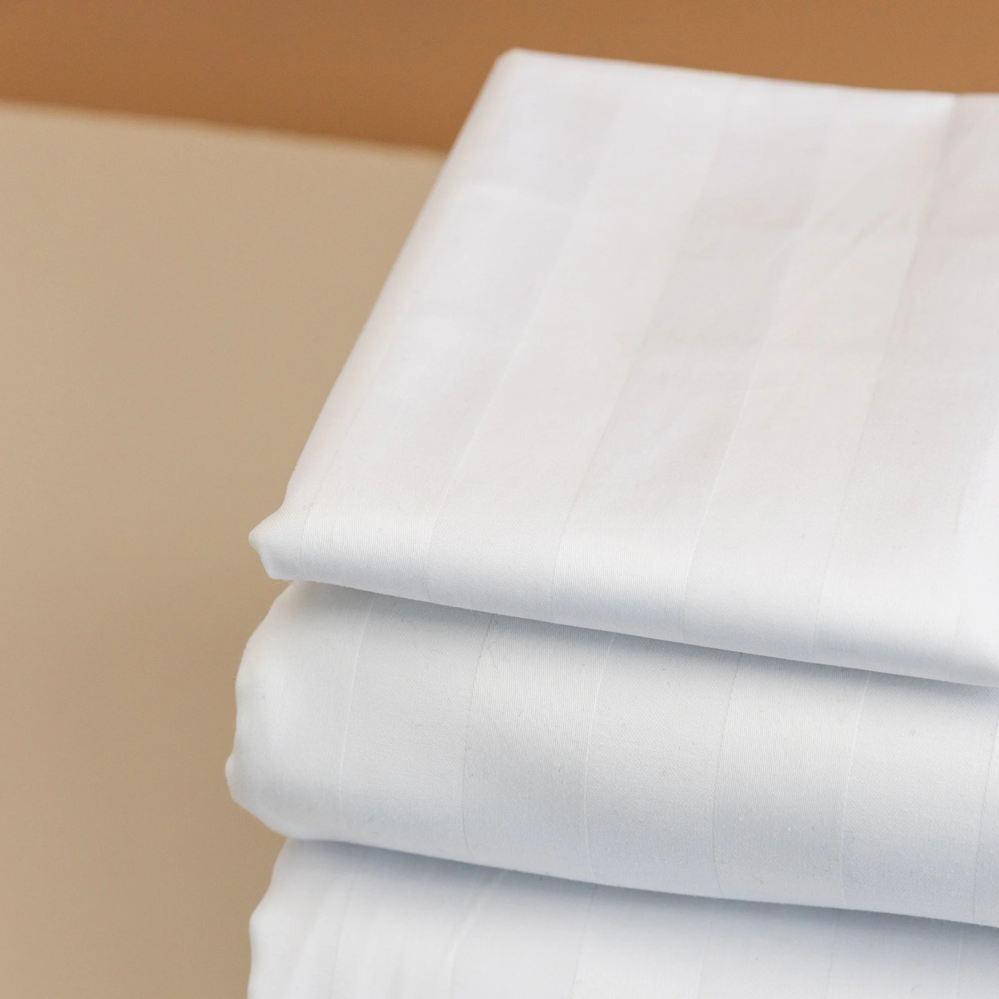 Close-up of folded white 25mm Rutherford Striped Sheet set.