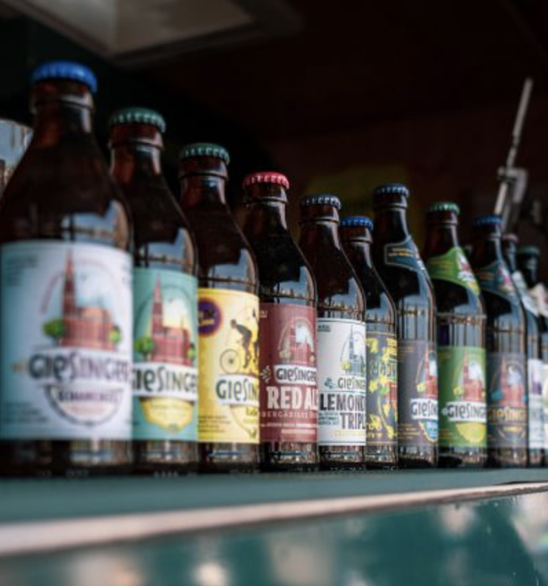 Mehrere Flaschen mit verschiedenen Biersorten auf einem Regal