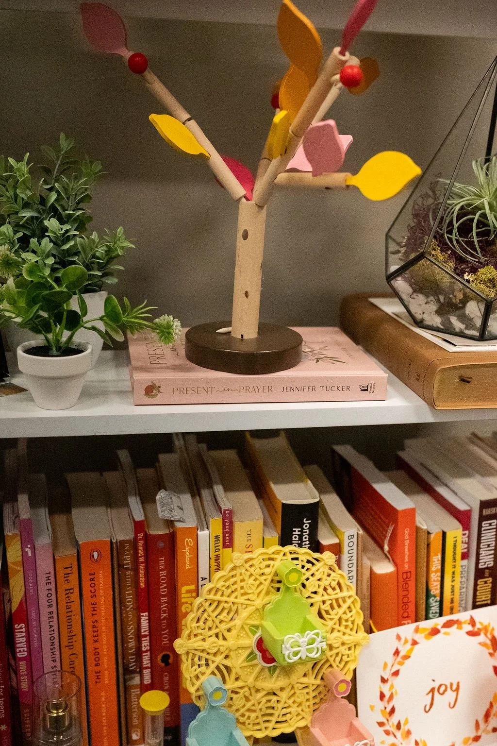 Prayer book, plants, and colorful wooden tree displayed in the Christian Family Care counseling office in Sioux Falls, SD.