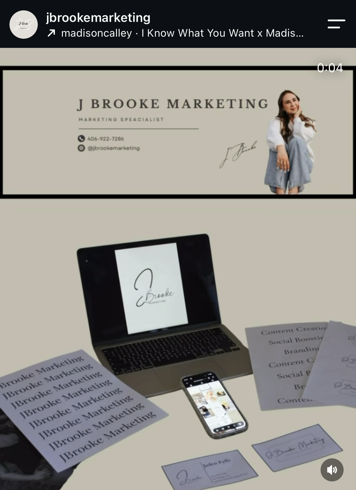 Business promotional display featuring a marketing expert named J Brooke, including a business card, a laptop displaying a logo, and printed marketing materials on a table.