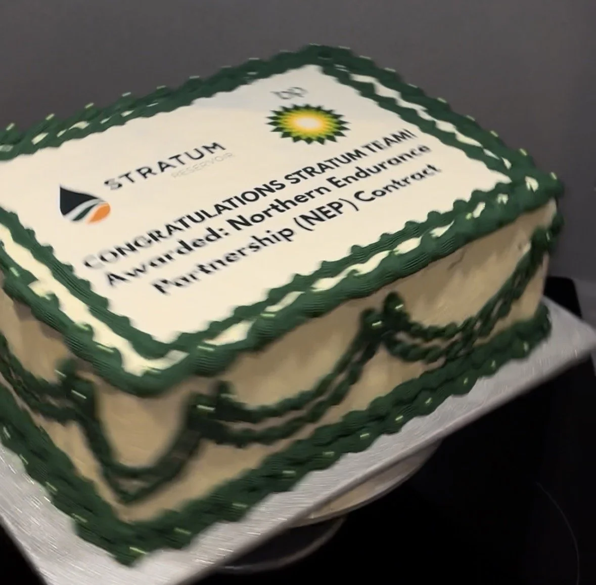 A cake with a green and white border, displaying a congratulatory message to Stratum for winning the Northern Endurance Partnership (NEP) contract.