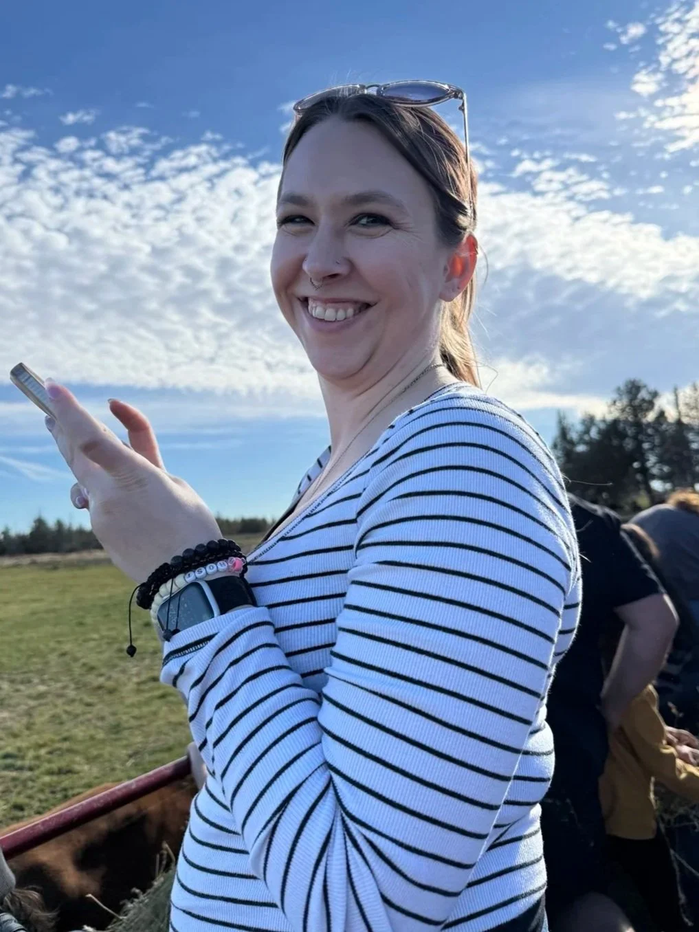 Johanna, birth doula and childbirth educator at Starlight Birth Services, smiling outdoors on a sunny day.