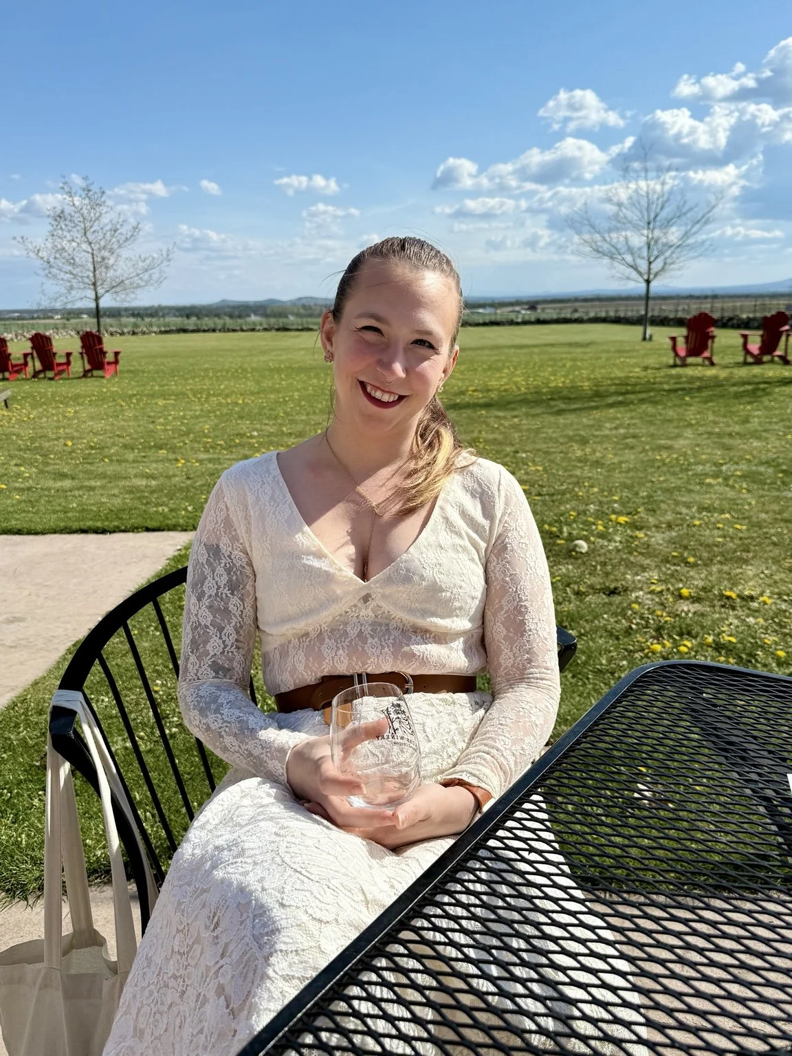 Johanna of Starlight Birth Services sitting outdoors at a table on a sunny day.