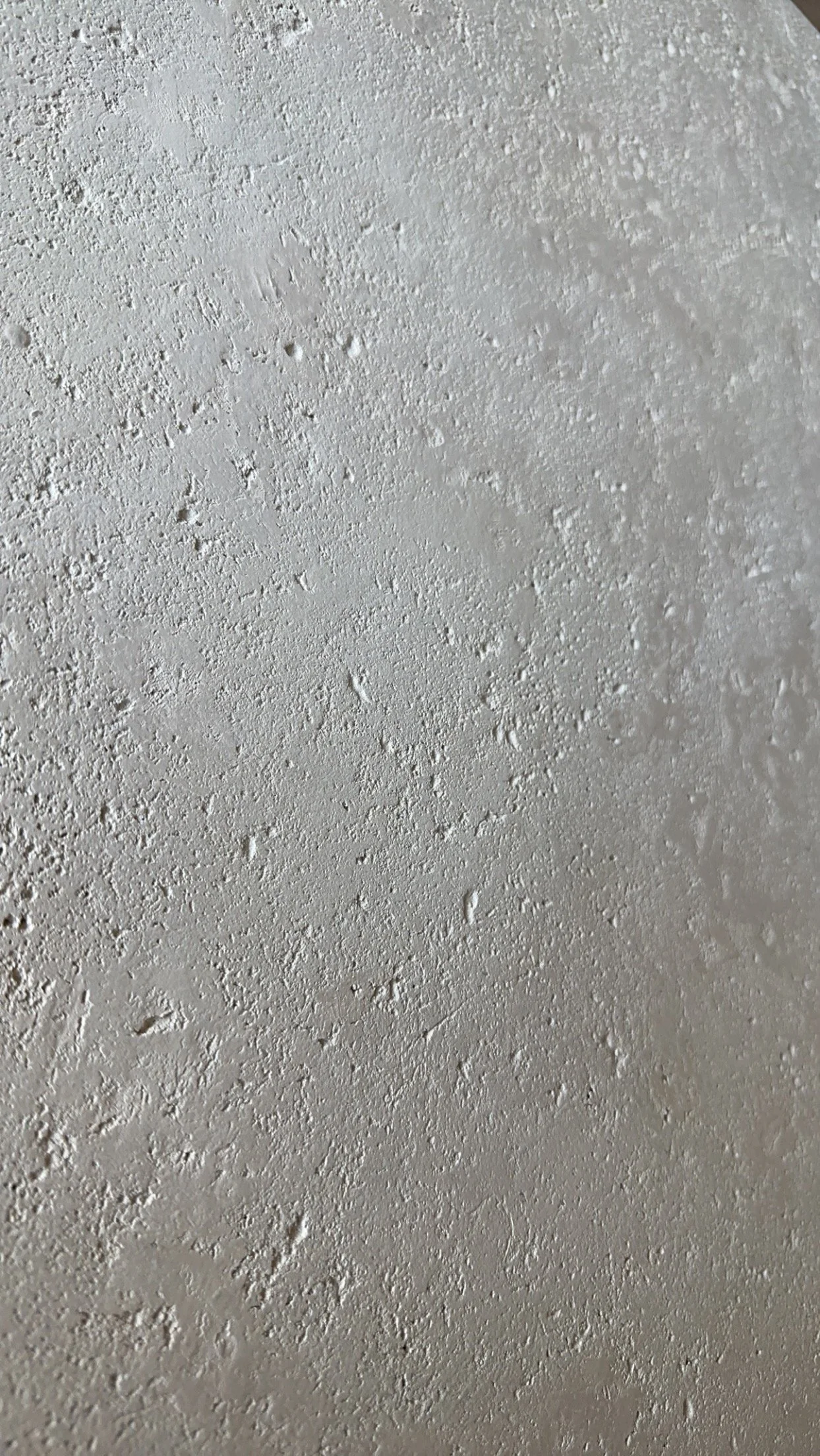 Close-up of a textured white ceiling with small bumps and irregularities.