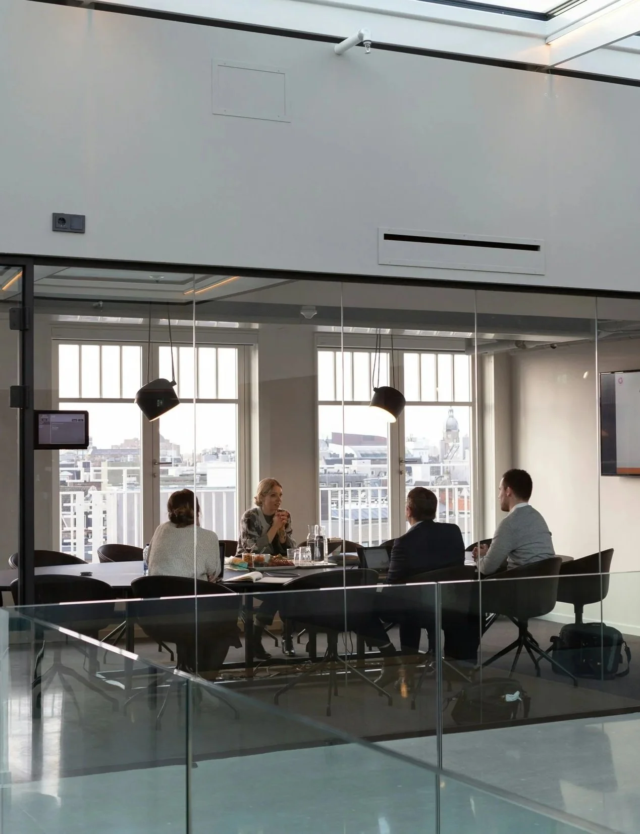Colleagues working at a desk in a sunny conference room
