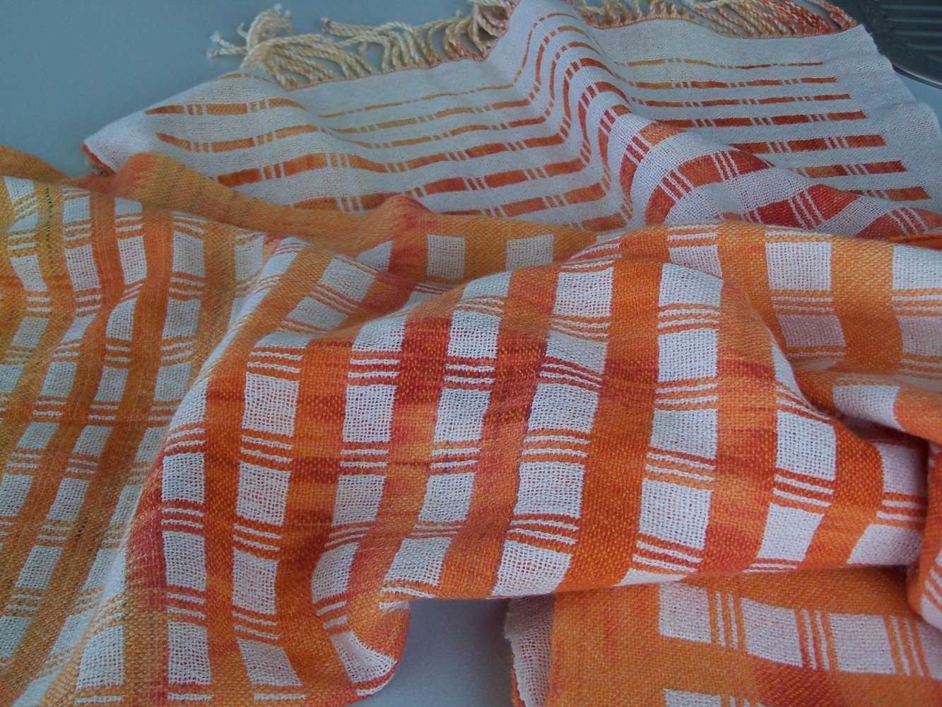 Close-up of orange and white checkered fabric with striped pattern.