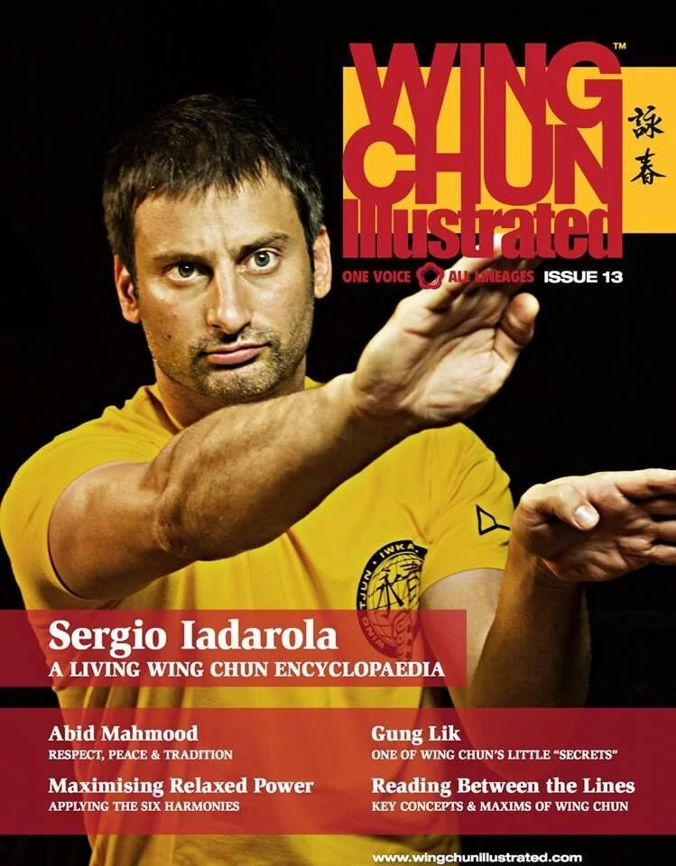 Cover of Wing Chun Illustrated magazine featuring Sergio Iadarola in a yellow shirt, performing a martial arts pose with a focused expression, with magazine title and article headlines in red and black text.
