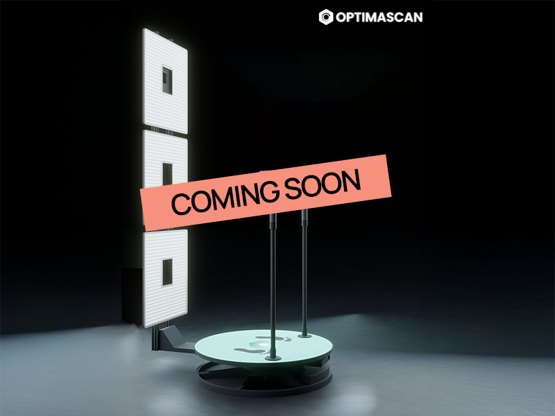 A modern LED display stand with two vertical poles, featuring an 'OPTIMASCAN' logo at the top right, and a red banner across the middle with the text 'COMING SOON' in black letters.