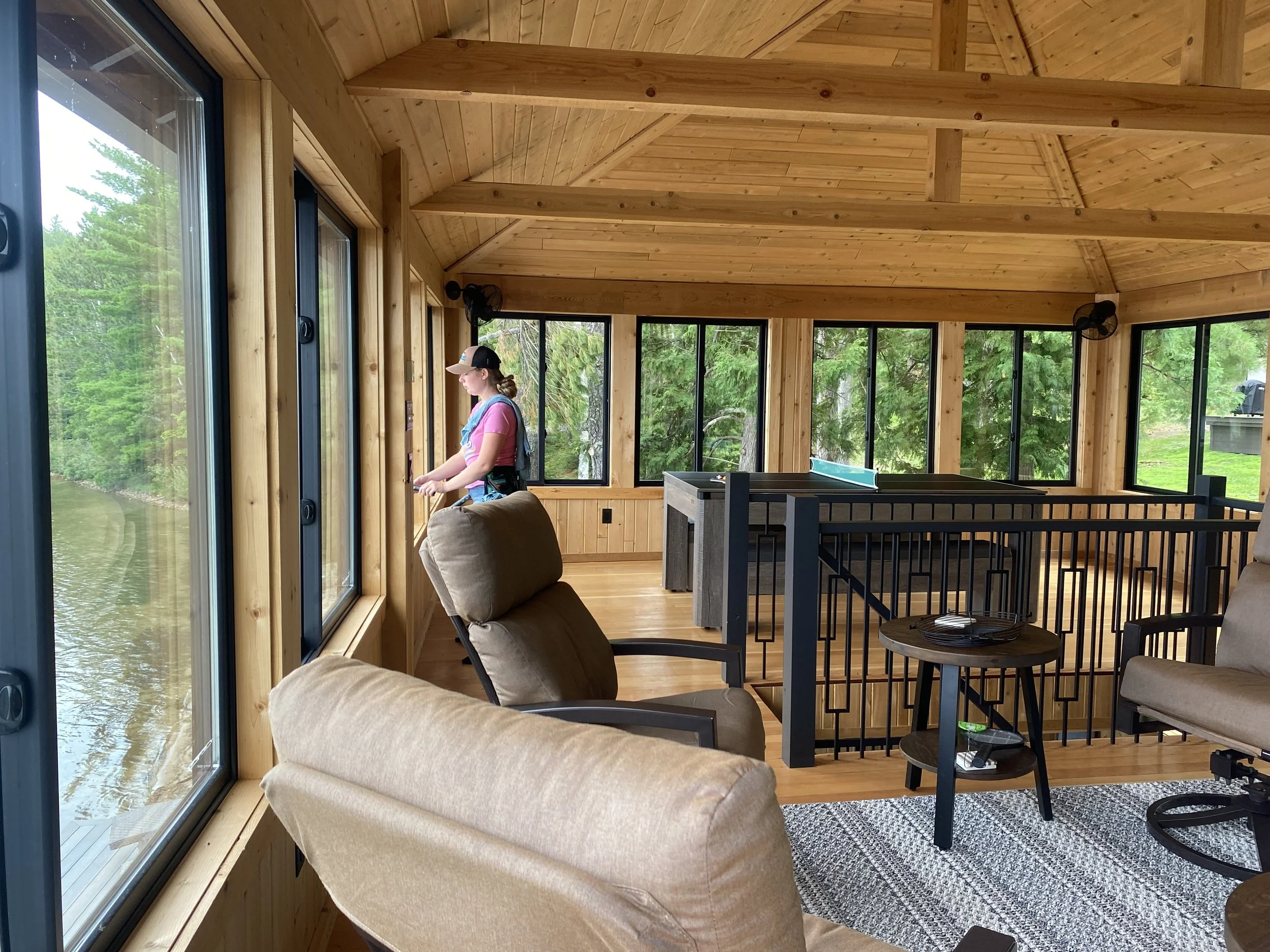 A window cleaner cleaning the main view windows in a tall boathouse
