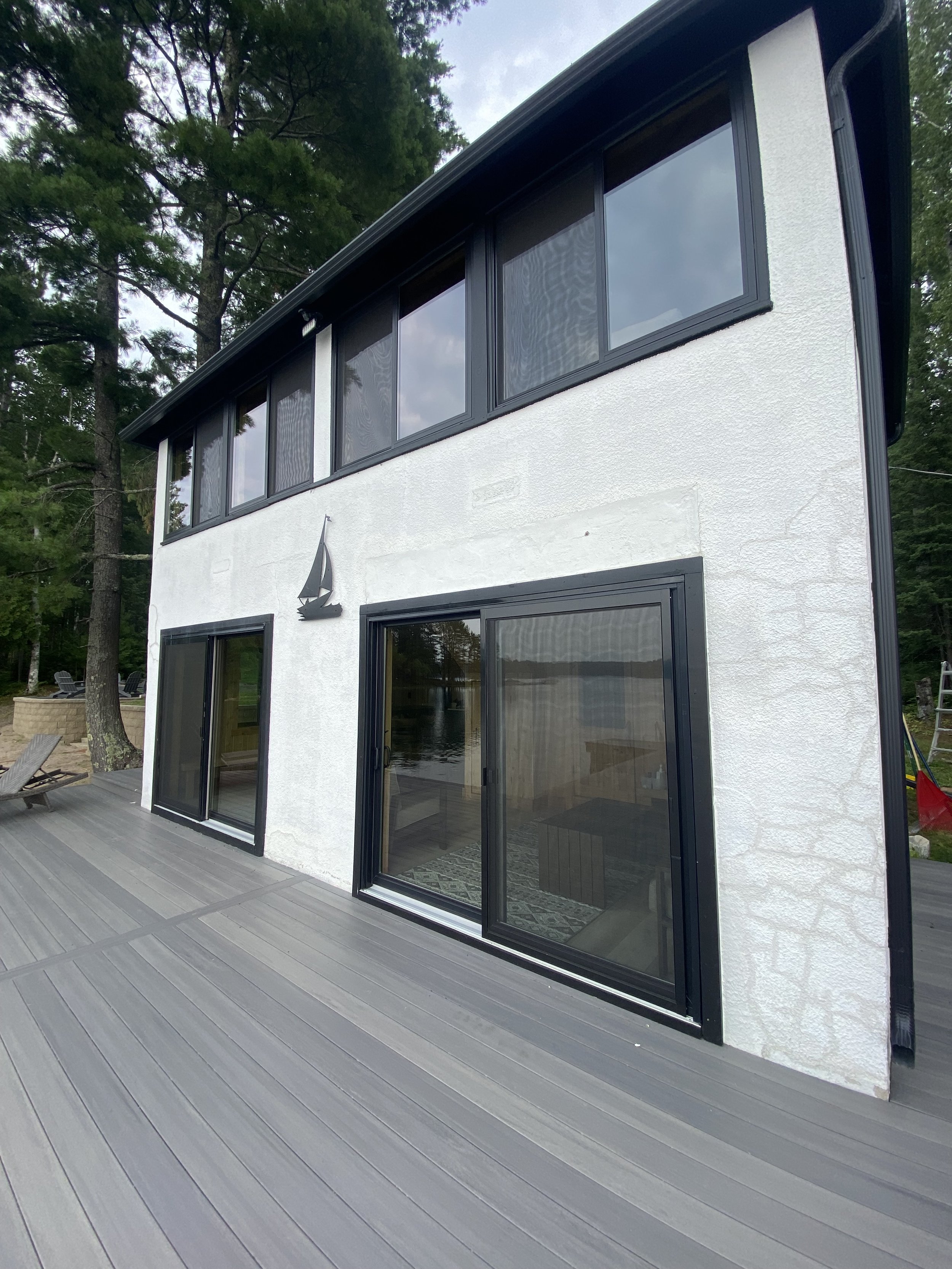 Modern white house with large sliding glass doors and windows, in the forest with professionally cleaned windows
