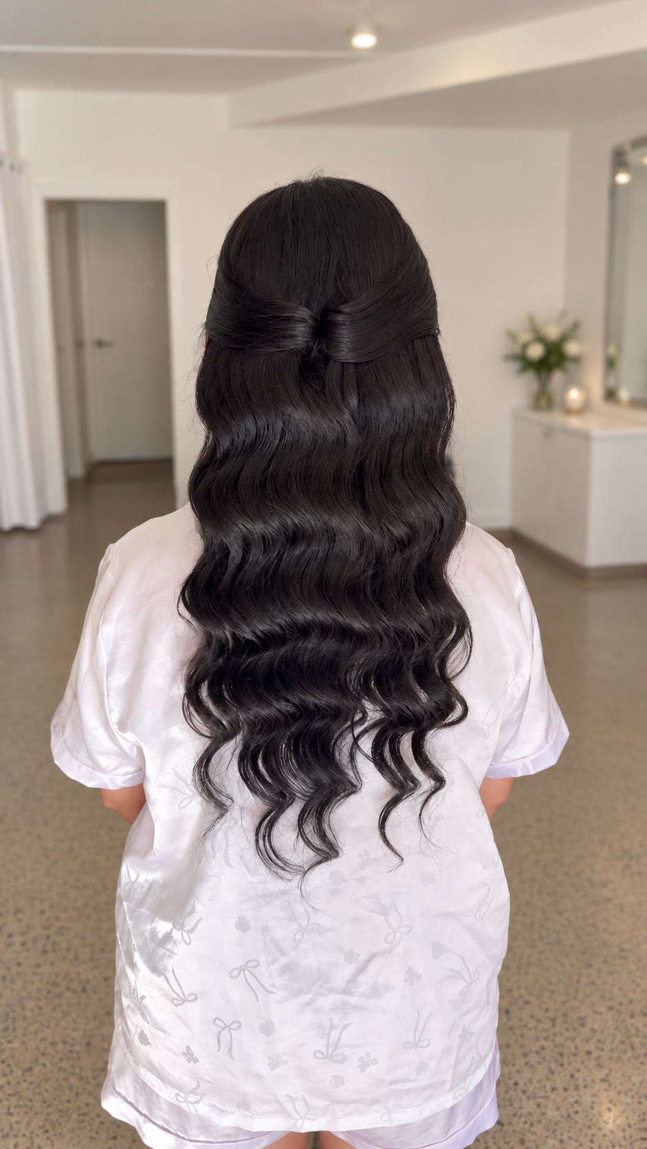 bride wearing clip in extensions, black shiny glam waves, half up style, front pull back